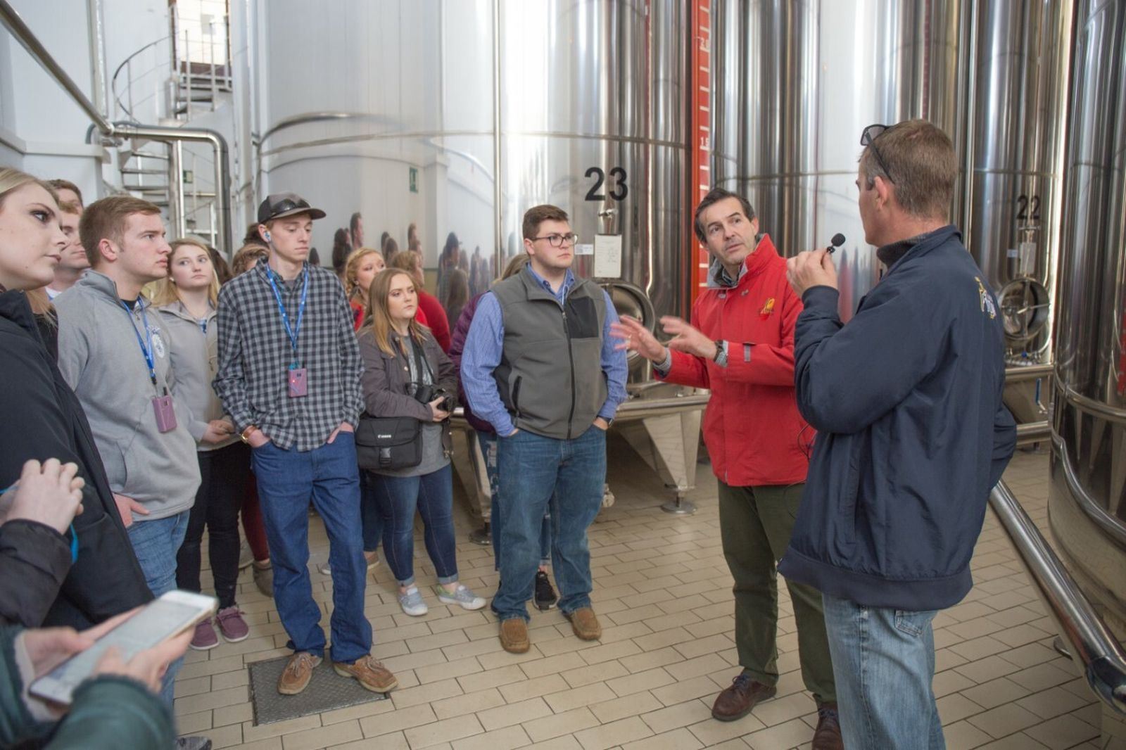 El grupo  de Future Farmers of America atiende a las explicaciones de Mosés Caballero, gerente de la Denominación de Origen Estepa, en la cooperativa San José, de Lora de Estepa.
