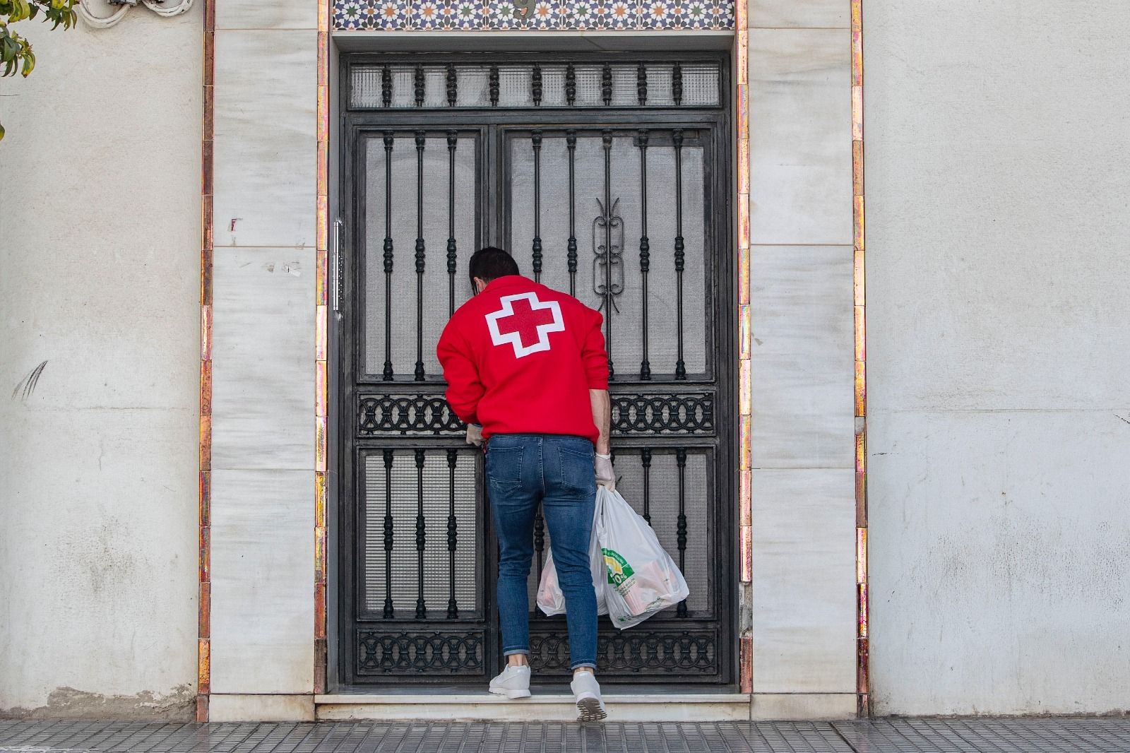 Un voluntario de Cruz Roja, en la puerta de un domicilio.