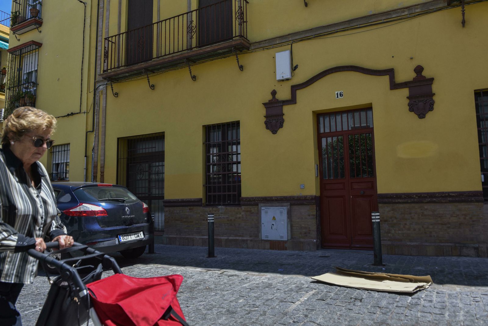 Una mujer pasa con un carro de la compra junto al edificio, enclavando en el número 16 de la calle Hiniesta.