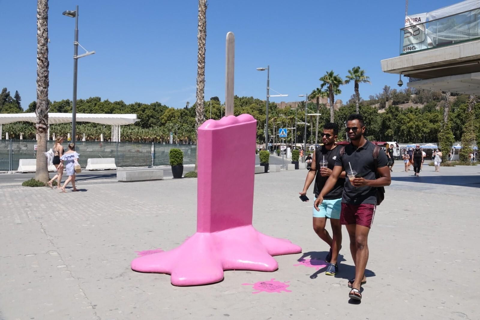 Dos turistas pasan junto a una escultura de un helado derretido, en Muelle Uno.