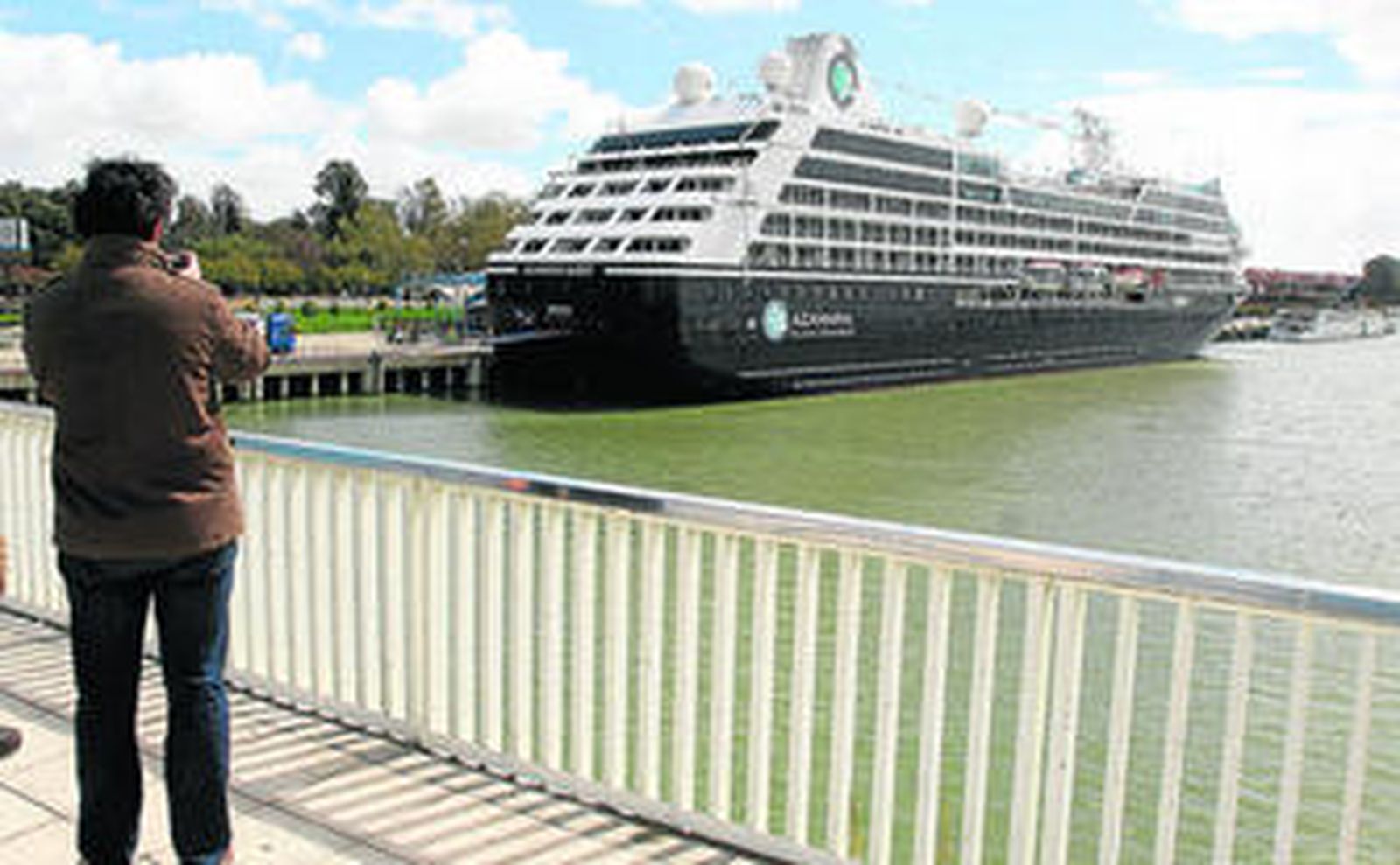 Numerosos sevillanos fotografían el 'Azamara Quest', atracado en el Muelle de las Delicias desde ayer.