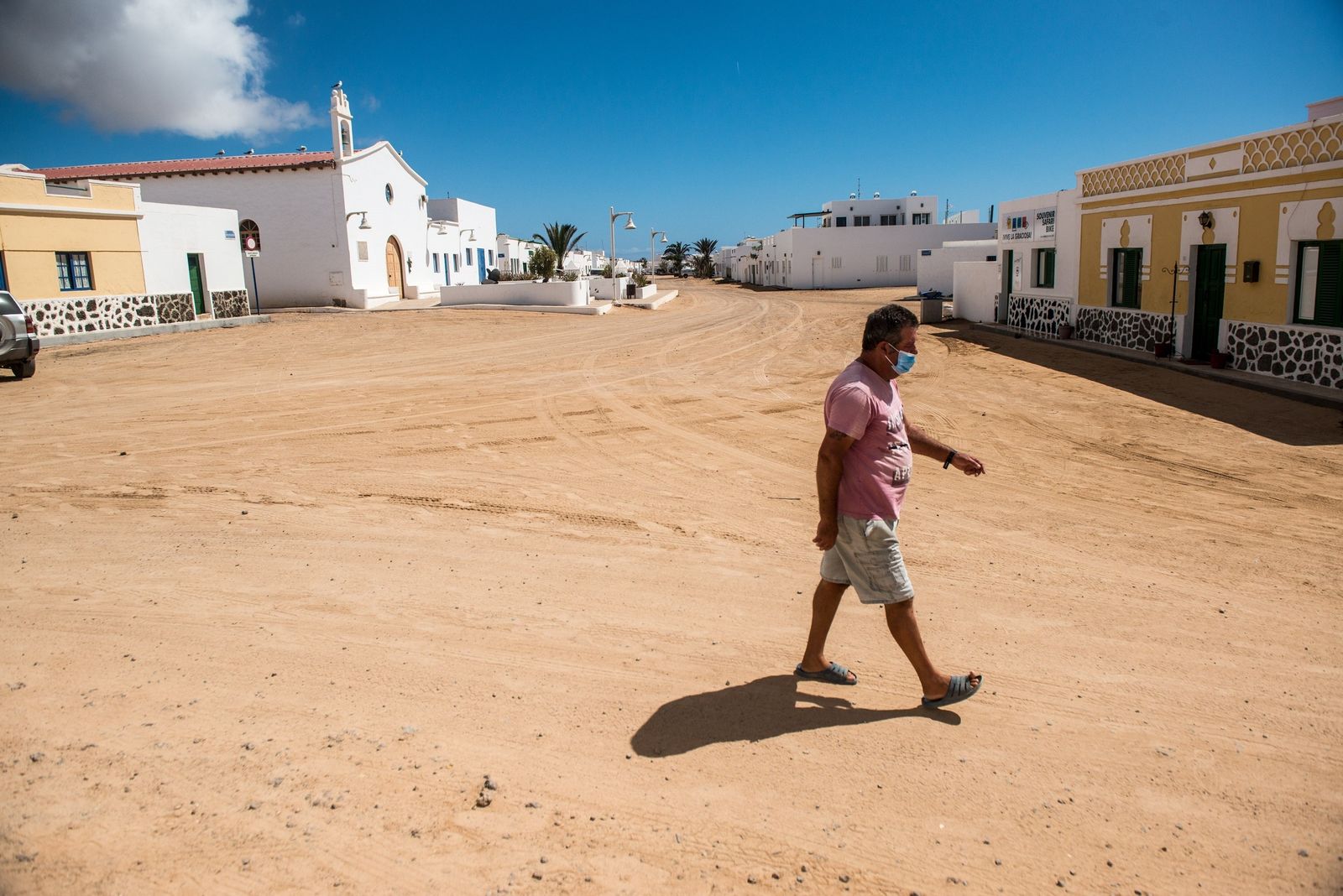 Un vecino graciosero, con mascarilla, por las calles de arena de La Caleta del Sebo