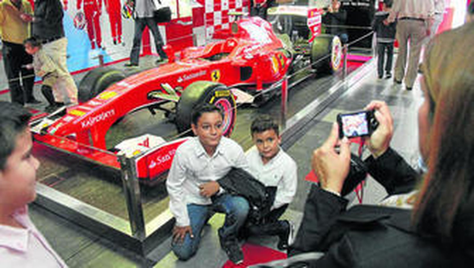 1. Unos niños junto a la réplica del Ferrari.               2. El alcalde de Huelva, Pedro Rodríguez, en uno de los simuladores. 3. Dos visitantes en los simuladores. 4. Cola en el exterior del Motorhome Santander. y 5. Niños montados en los coches del circuito hinchable.