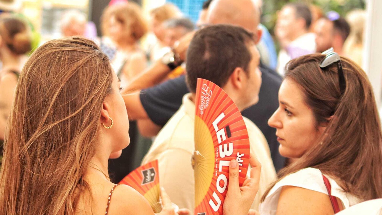 Dos mujeres con abanicos en el interior de una caseta.