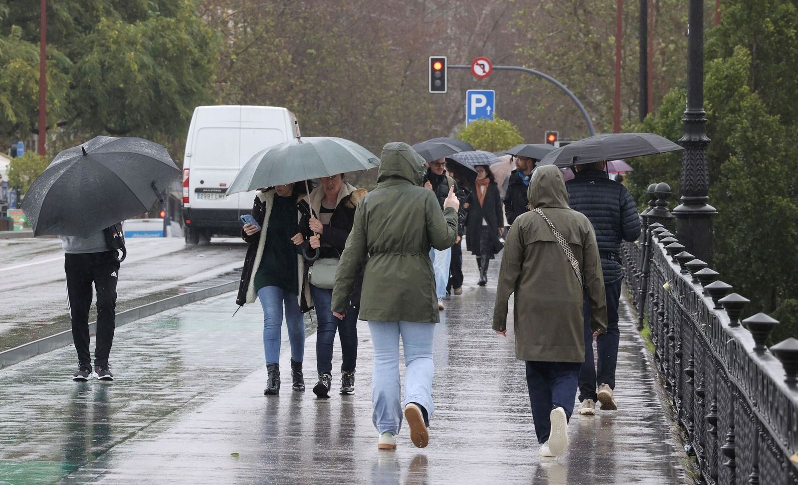 Varias personas bajo la lluvia en Sevilla.