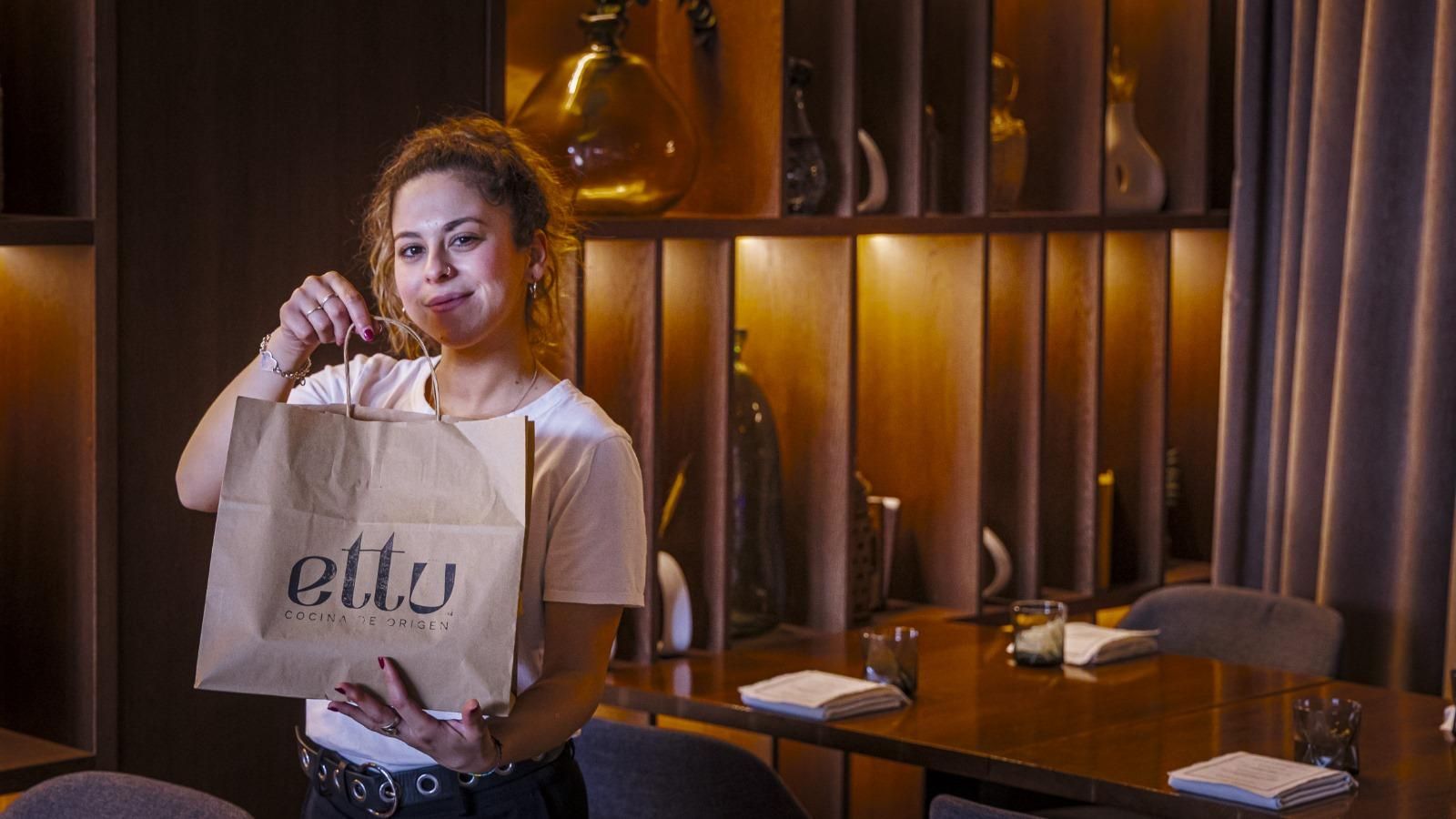 La trabajadora de un restaurante gaditano, con una bolsa de comida para llevar.