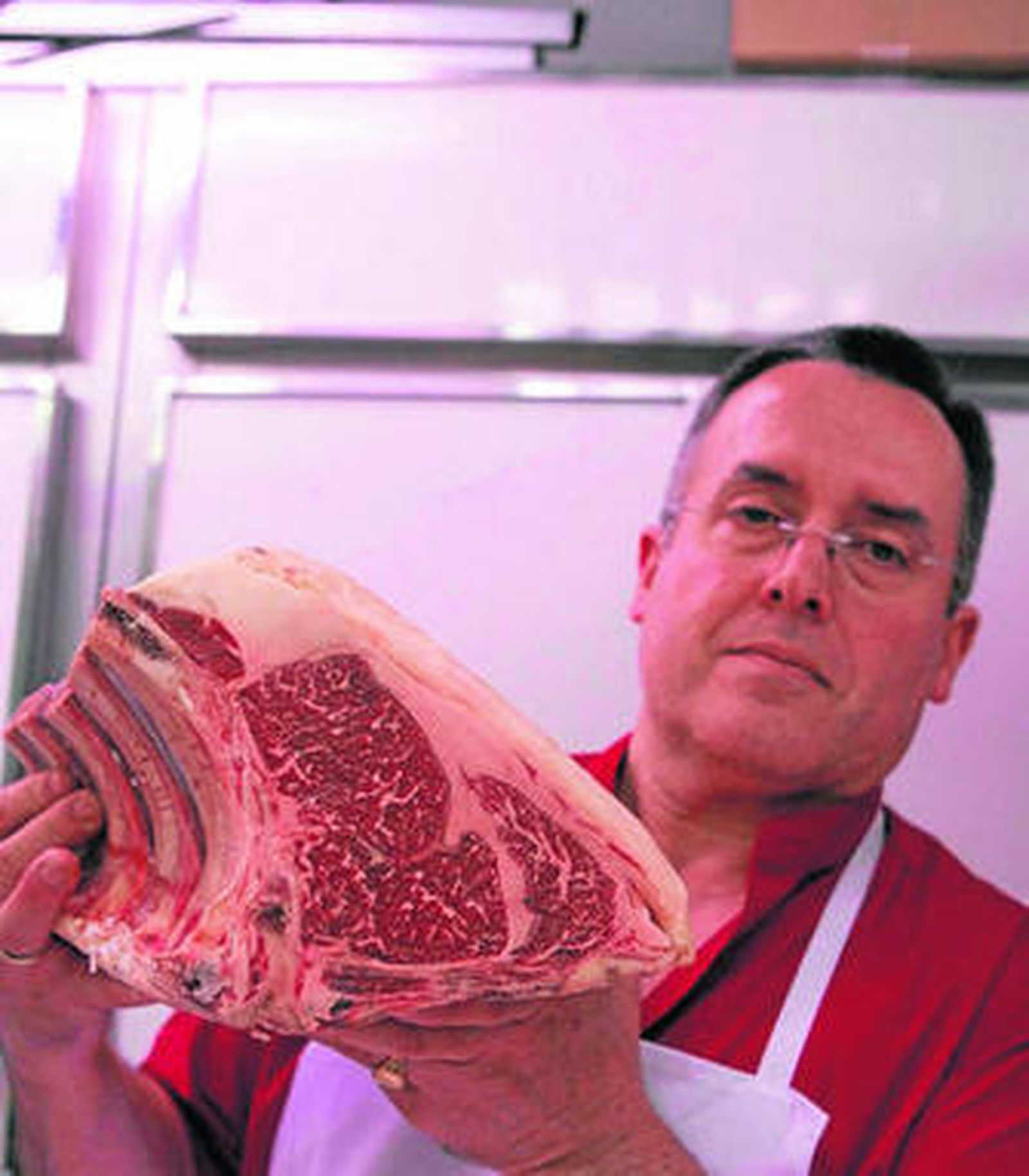 Antonio Cañadas posa junto a un chuletón de su carnicería.