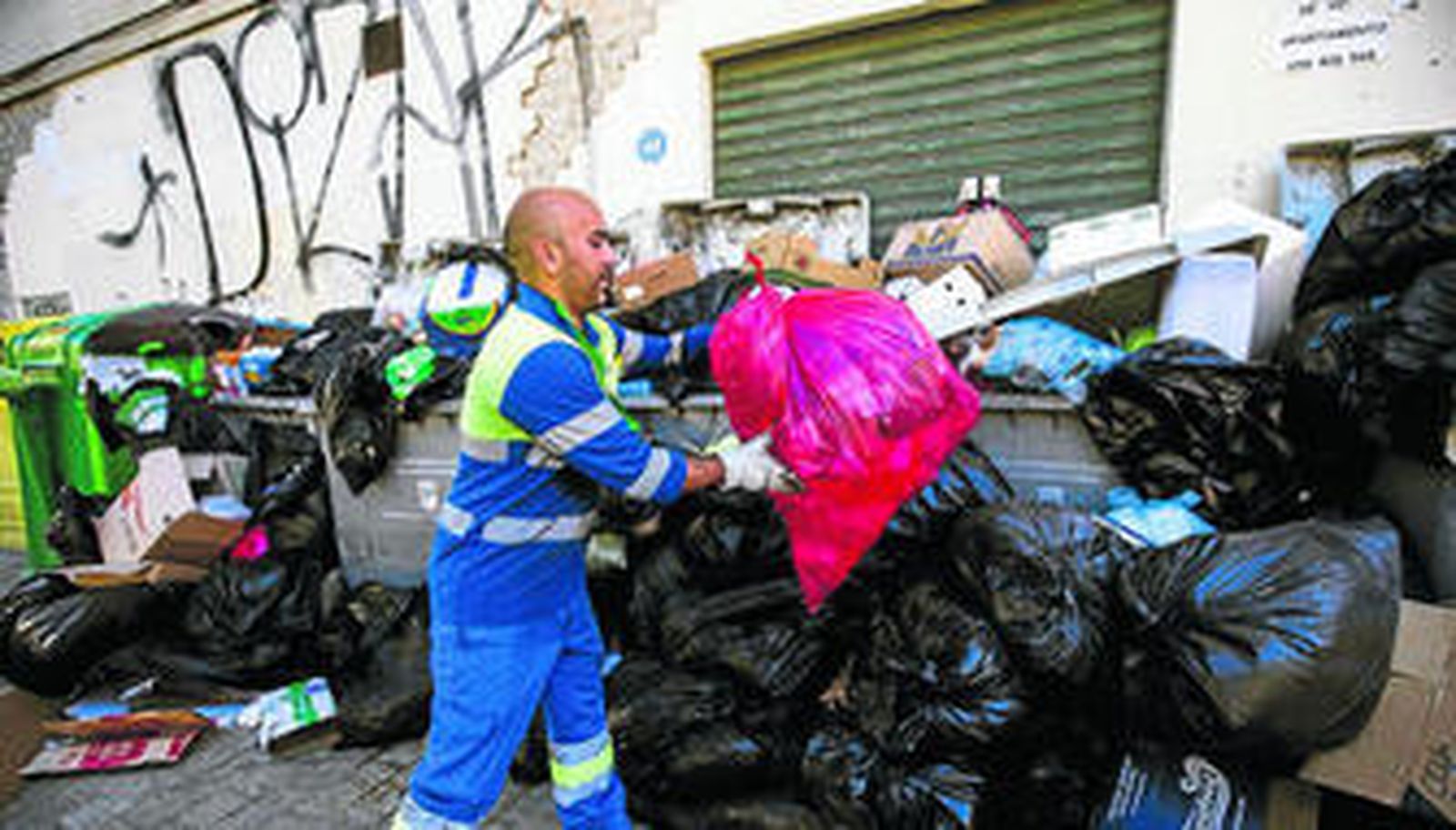 Un operario de Limasa recoge la basura de un contenedor durante la huelga del pasado mes de marzo.