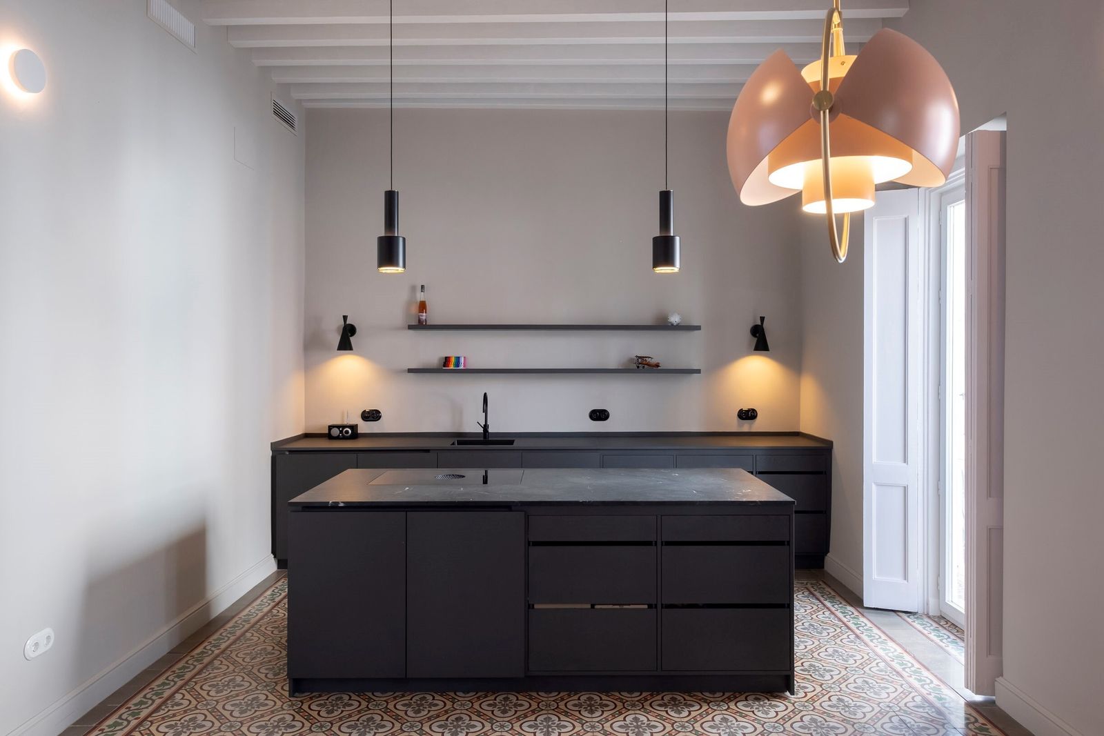 Cocina. Mobiliario en tono gris con encimera de mármol e isla en la parte central, combinado con el hidráulico de su suelo.