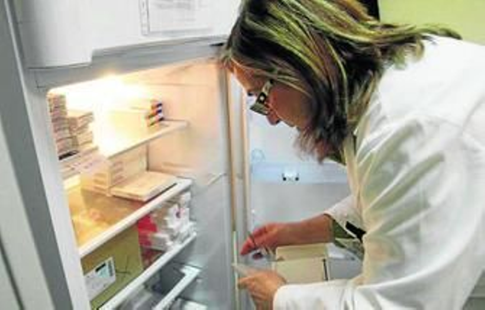Una profesional sanitaria busca vacunas en una nevera en un centro de Granada.