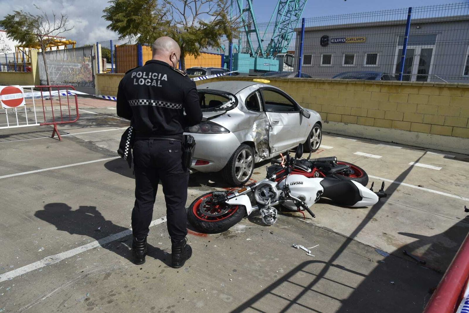 Un agente de la Policía Local, junto a los vehículos implicados en el accidente.
