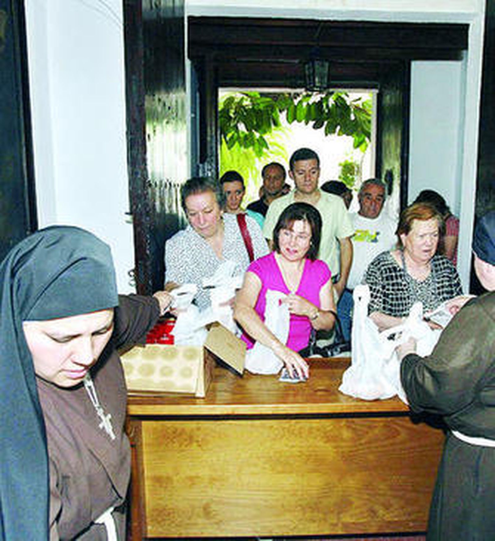 Las hermanas entregan las bosas de pan a los fieles.