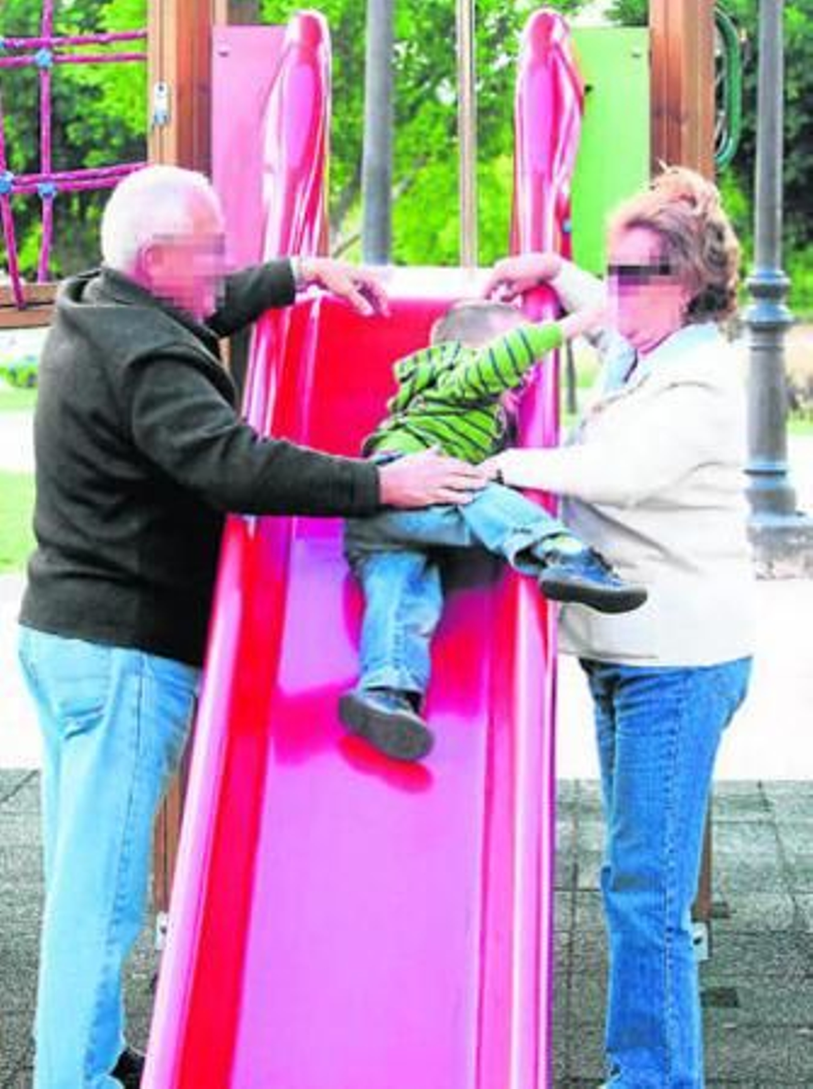 Unos abuelos juegan con su nieto en un parque de Málaga.
