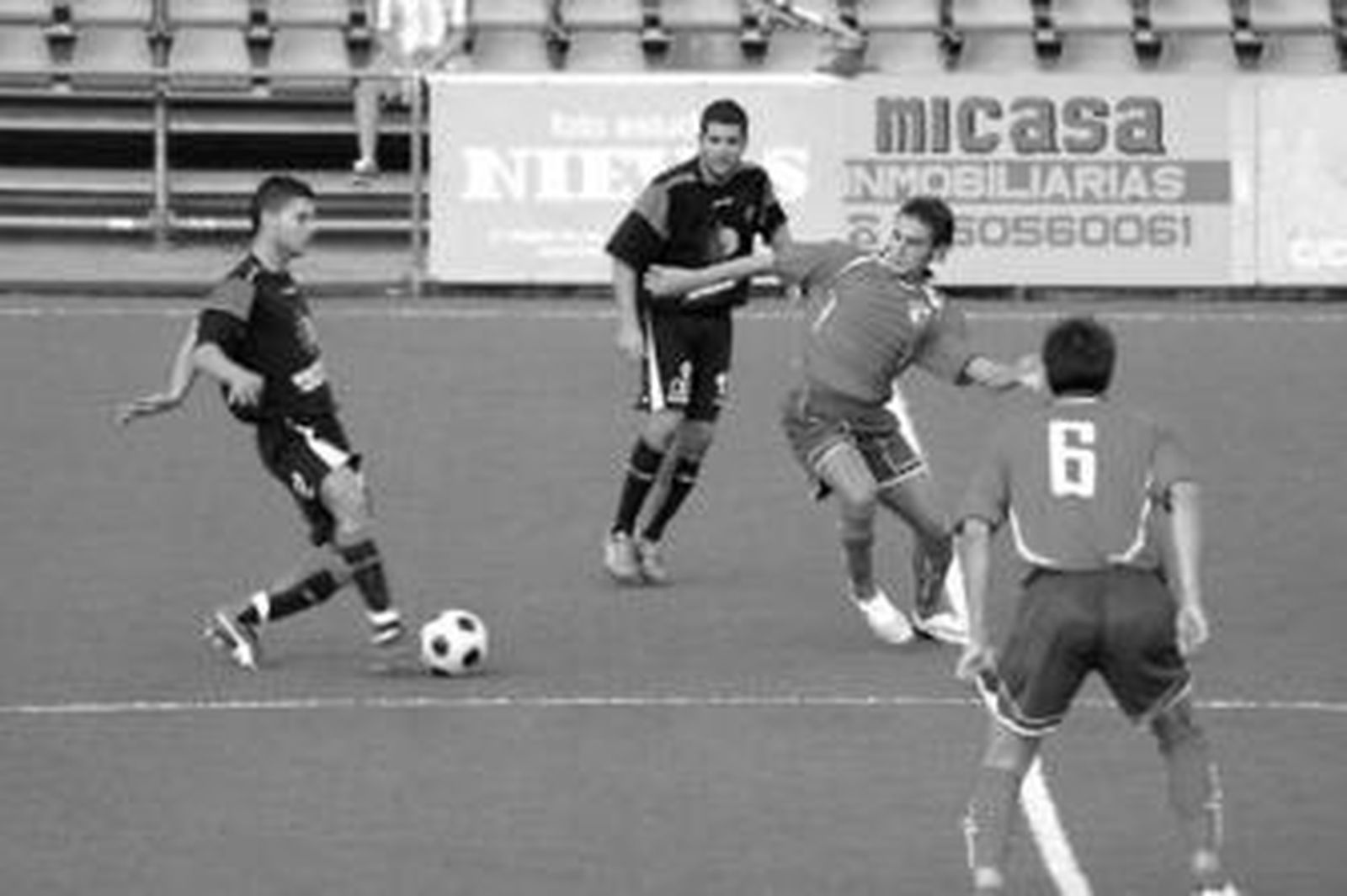 Beltrán, golpeando el balón, en un amistoso frente al Adra, con Romario de fondo.