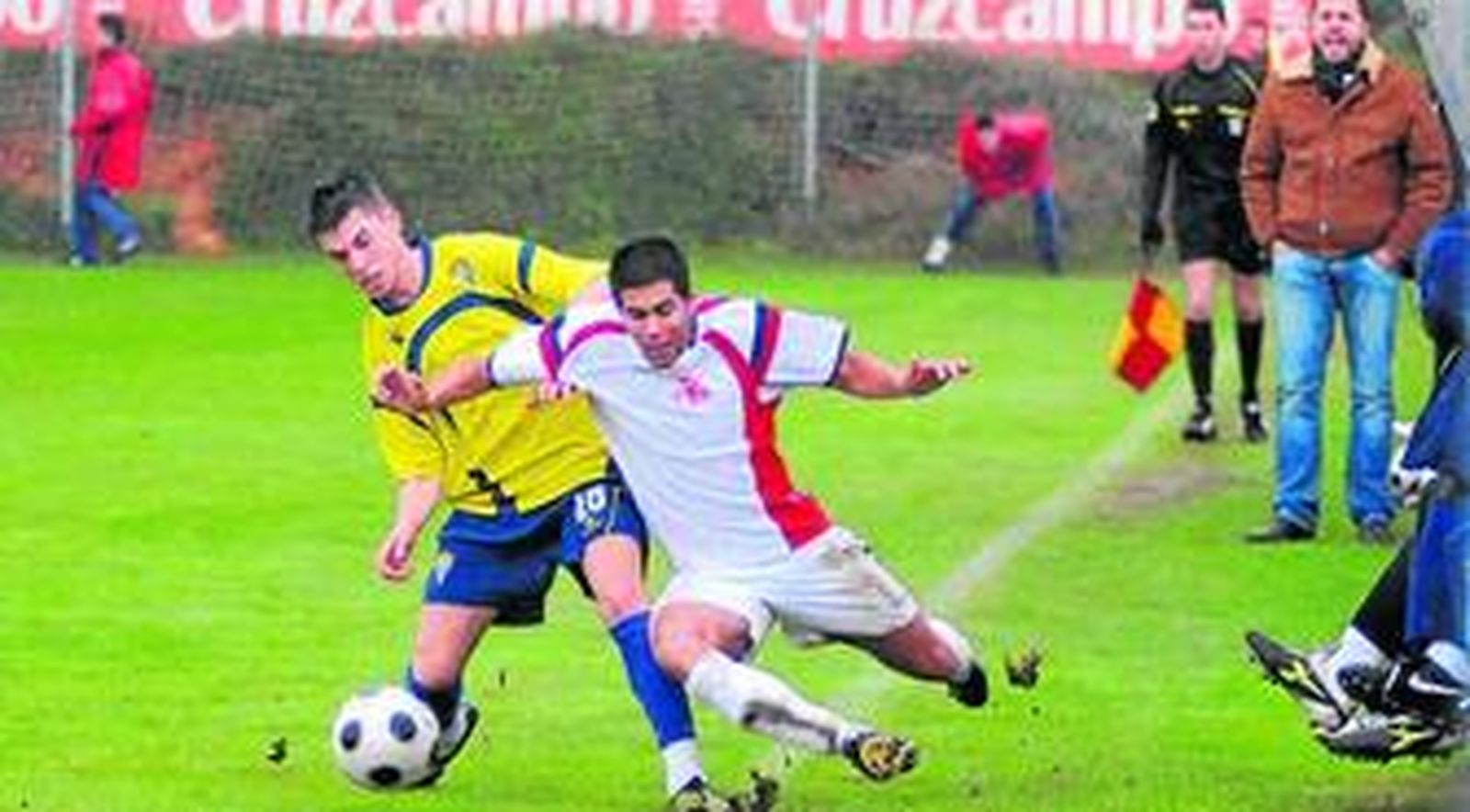 El balonista Álex Torres derriba a Carlos Martínez, extremo zurdo del Chiclana que debutó con el Cádiz en la temporada 2007-2008.