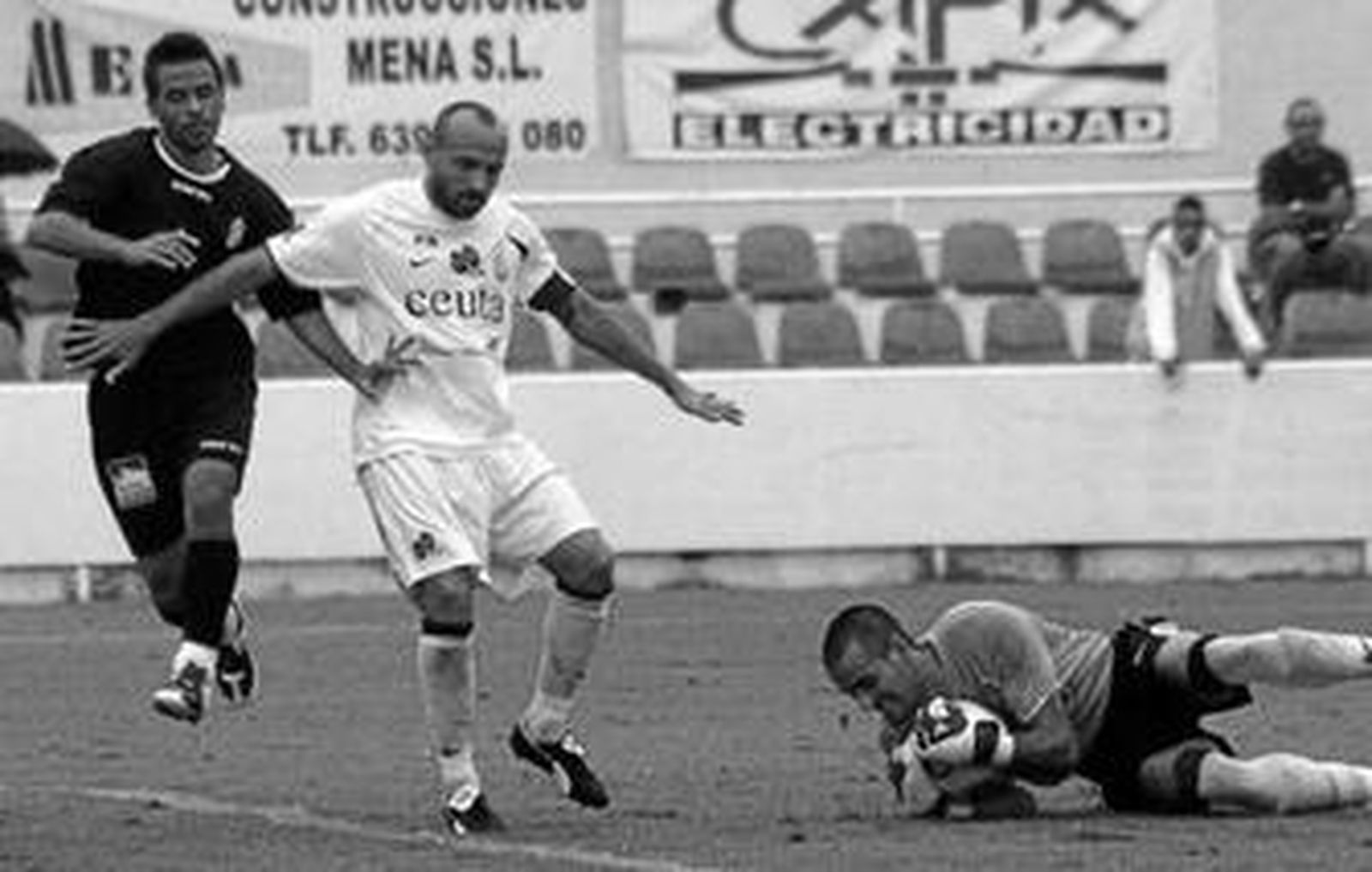 El guardameta del Ceuta, Ramón, ataja el cuero mientras sandro protege la llegada de Felipe.
