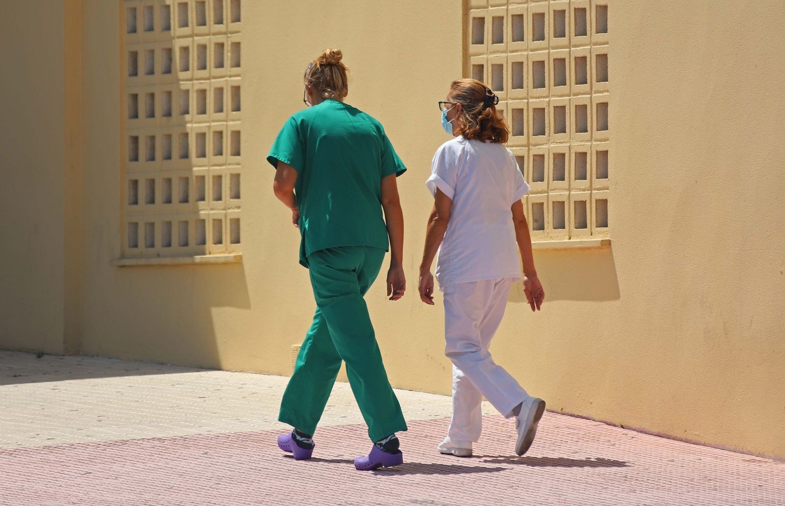 Dos profesionales del Punta Europa caminan hacia el interior del hospital