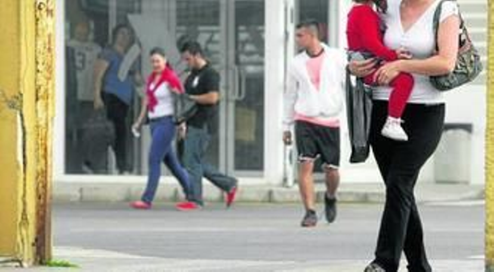 Una mujer con una bolsa con tabaco y otra pareja al fondo cruzan la Verja hacia La Línea.