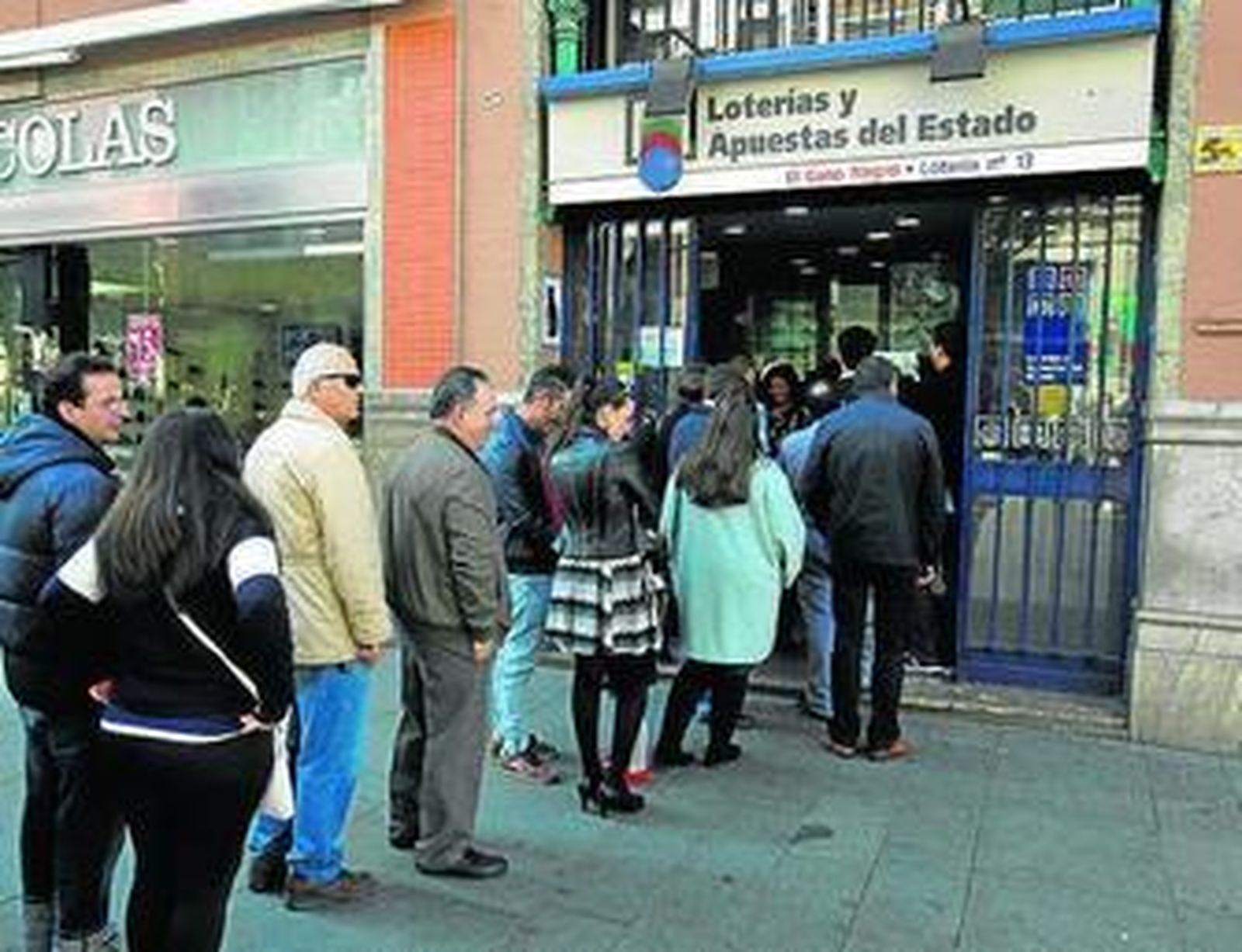 Cola de personas ayer en la Avenida para comprar loteria en El Gato Negro.