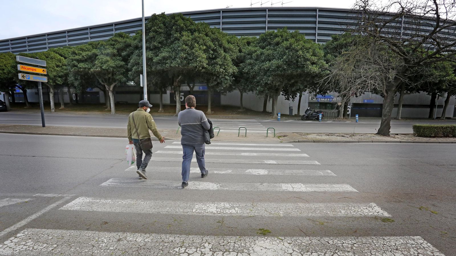 Dos hombres cruzan en dirección al estadio de Chapín la mañana de este jueves.