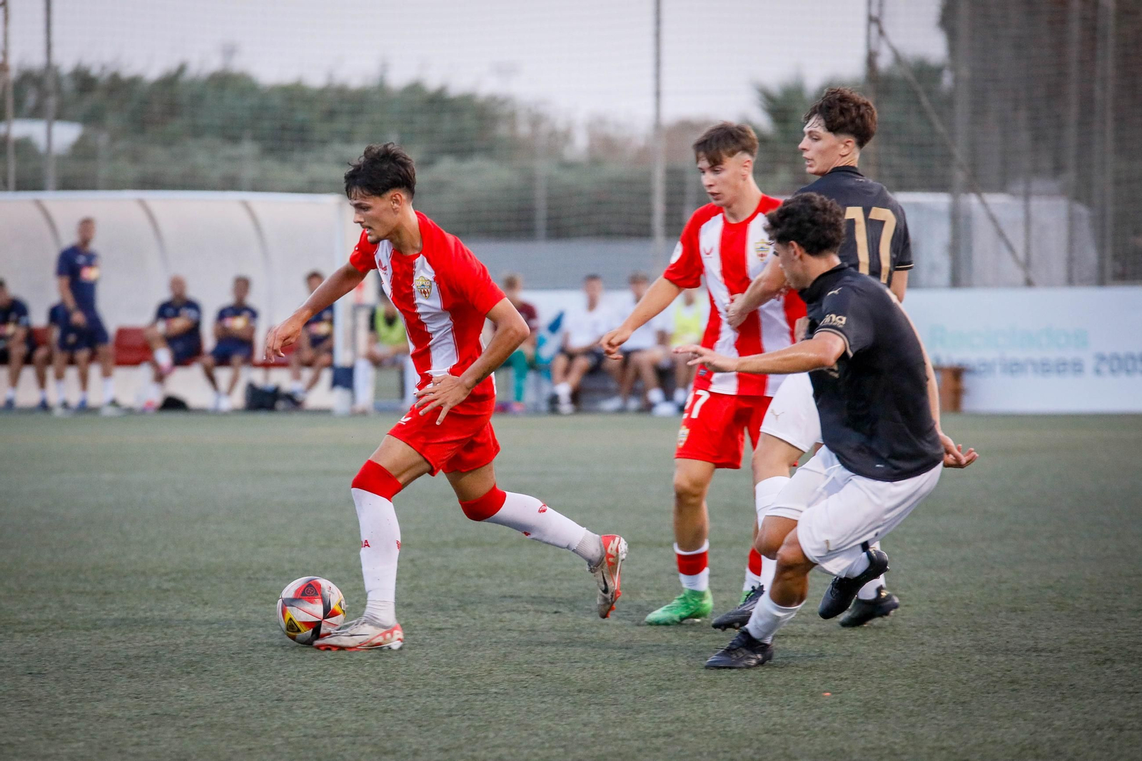 Un jugador del conjunto rojiblanco conduce el balón ante la oposición rival durante el trofeo de Feria Juan Oncala