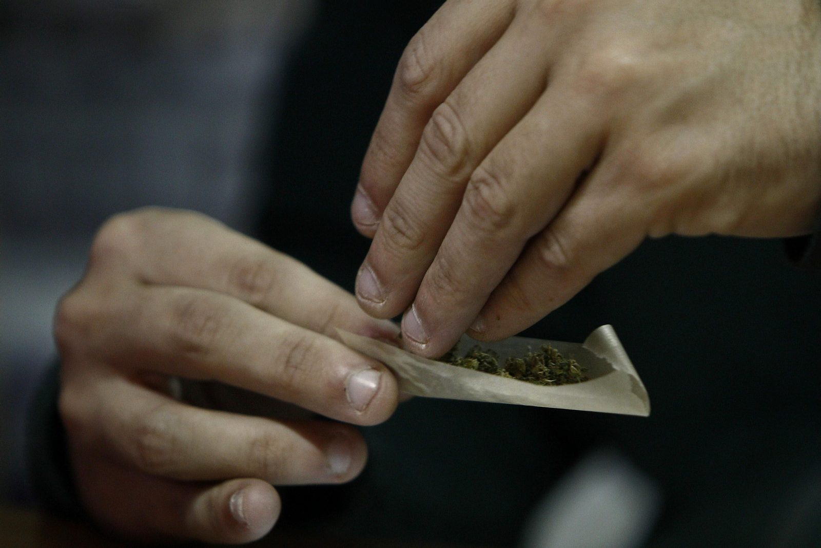 Una persona se prepara un cigarrillo con marihuana.