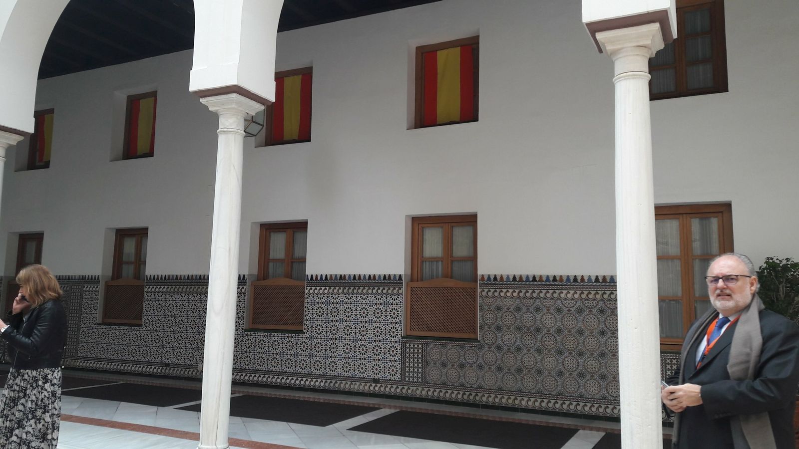 Banderas como cortinas en las ventanas del grupo parlamentario de Vox.