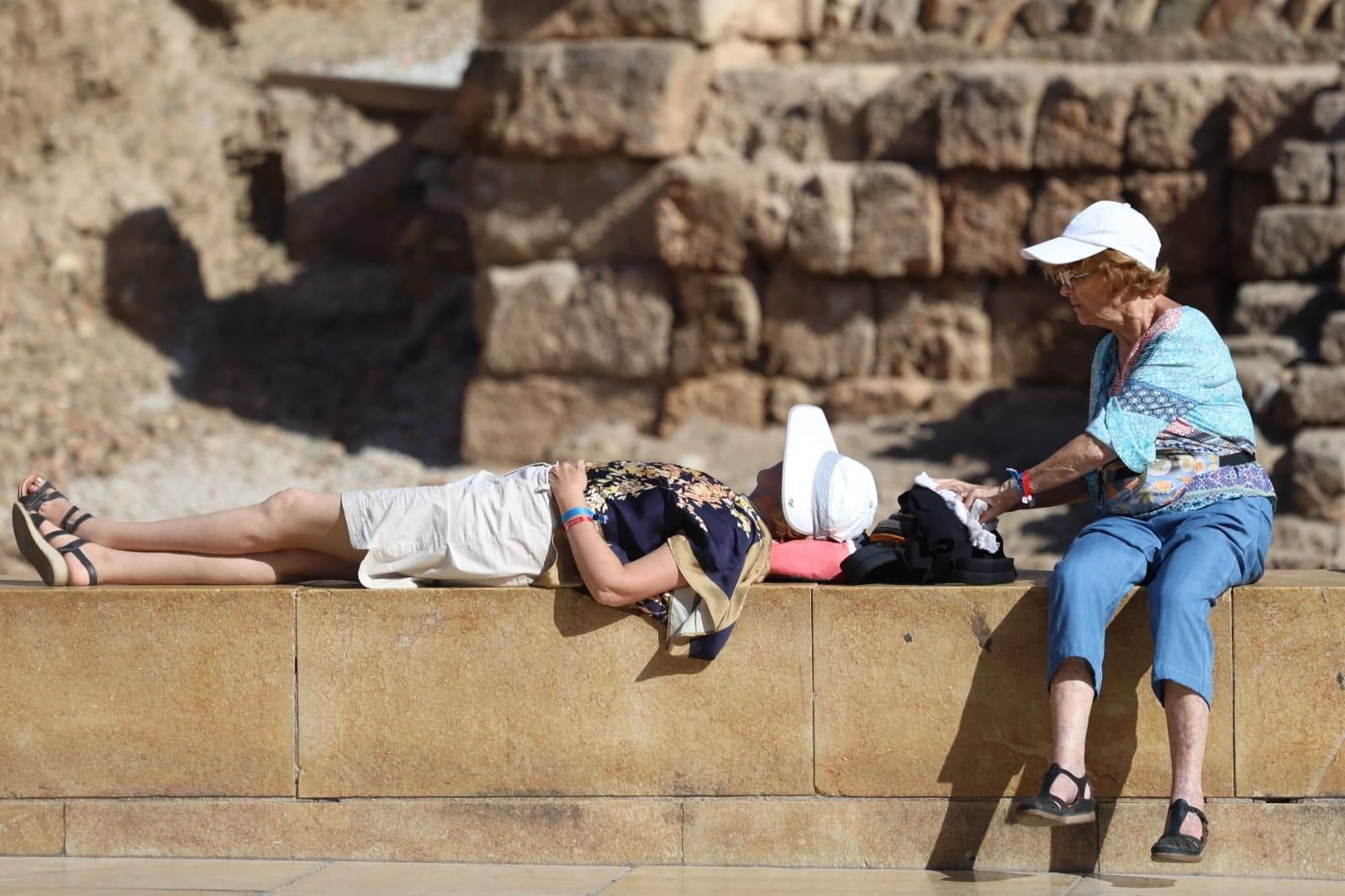 Dos mujeres en el centro d eMálaga refugiándose del calor con sombrero y gorra. Dos mujeres en el centro d eMálaga refugiándose del calor con sombrero y gorra.