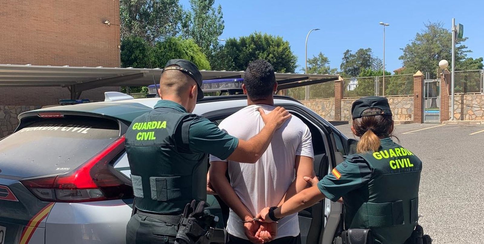 La Guardia Civil introduce al detenido en uno de los coches patrulla del cuerpo.