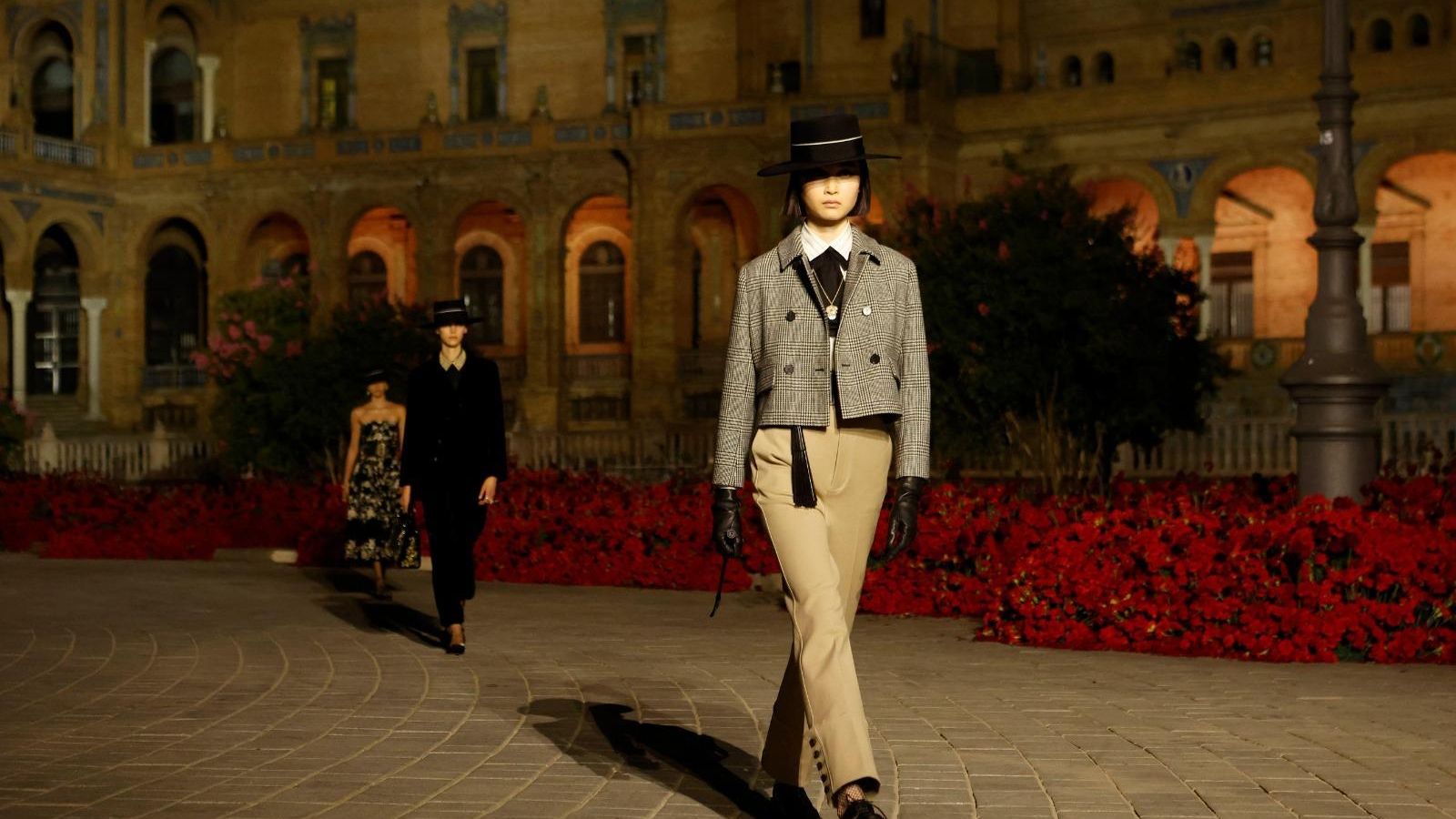 Con pantalón, chaqueta y sombrero.