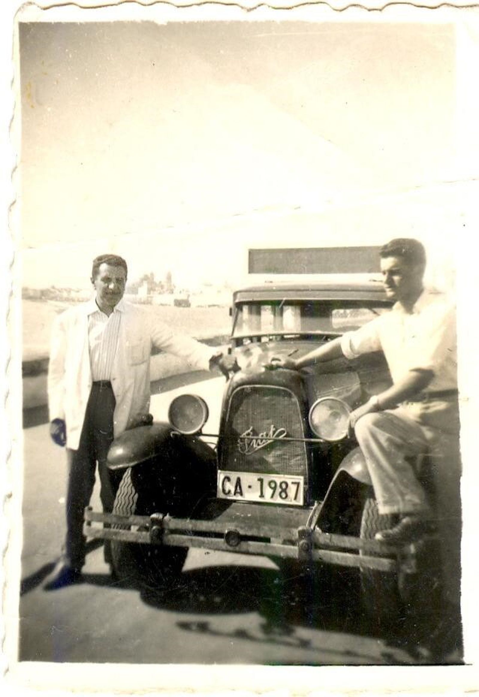 Imagen de Sinforoso Barrigá con un alumno ante uno de los primeros coches de la autoescuela, un Fiat.