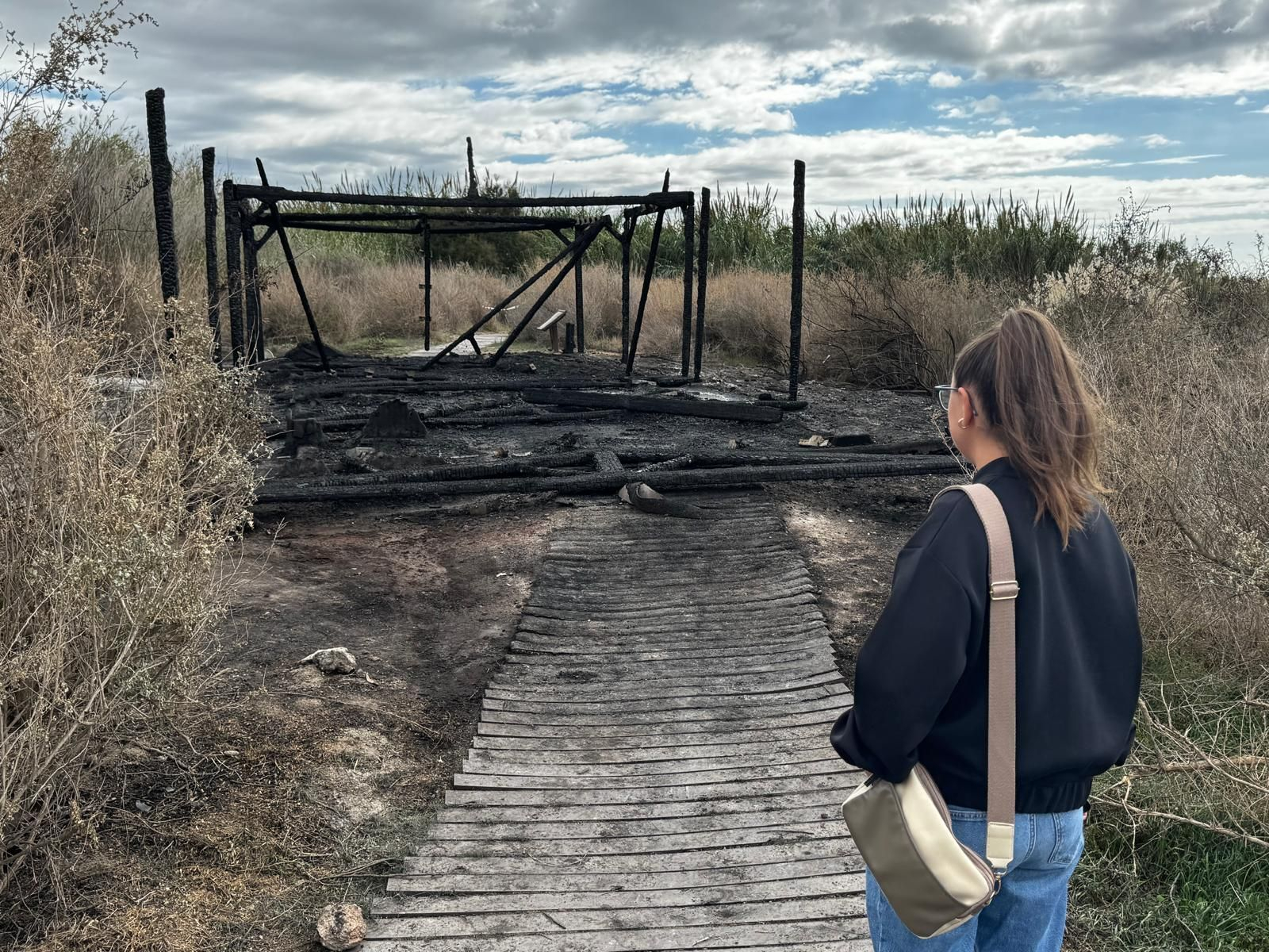Una joven mira la zona quemada