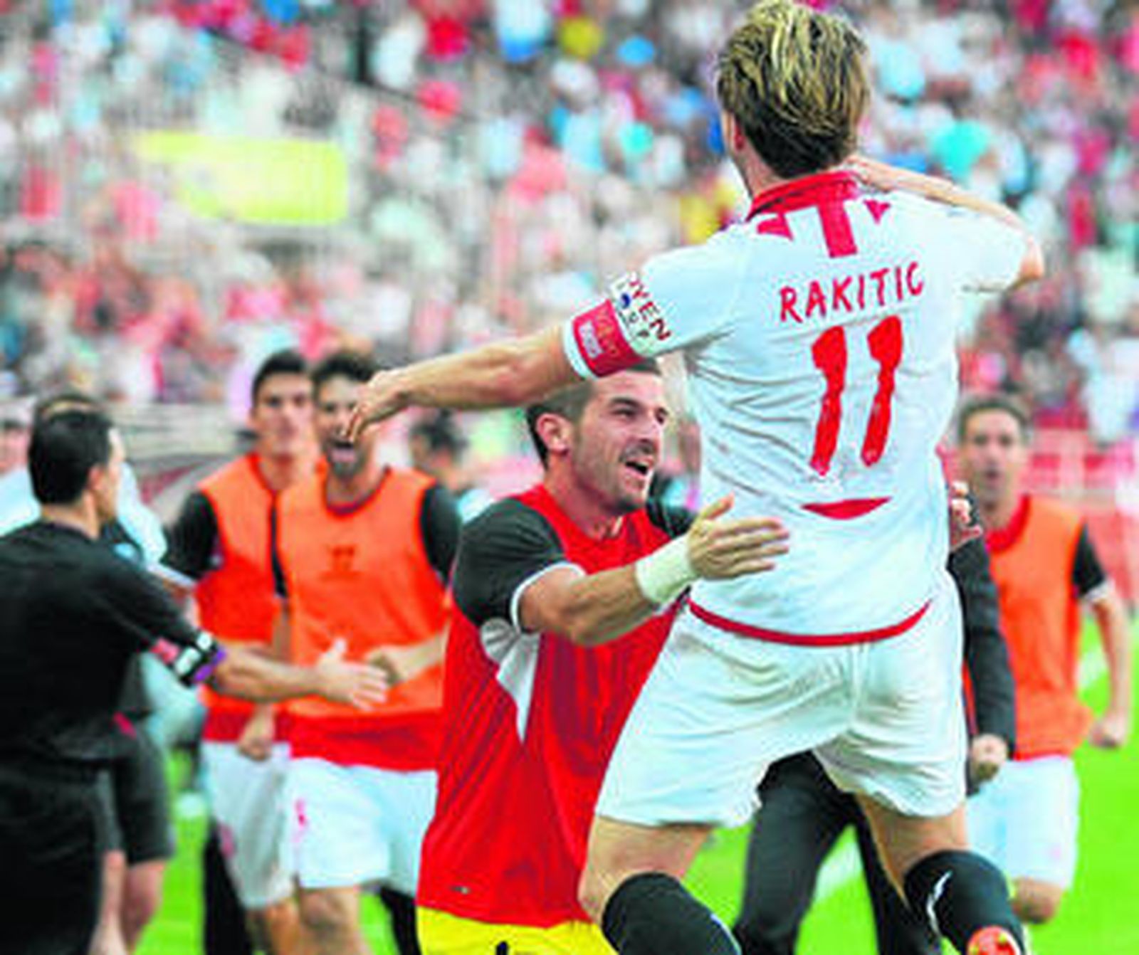 Rakitic salta para abrazarse a Javi Varas y a otros compañeros junto al banquillo del Sevilla.