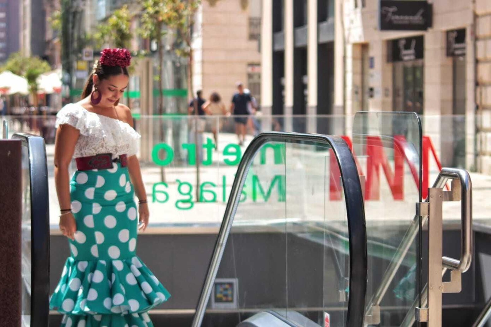 Una mujer vestida de flamenca saliendo del Metro en el centro. Una mujer vestida de flamenca saliendo del Metro en el centro.