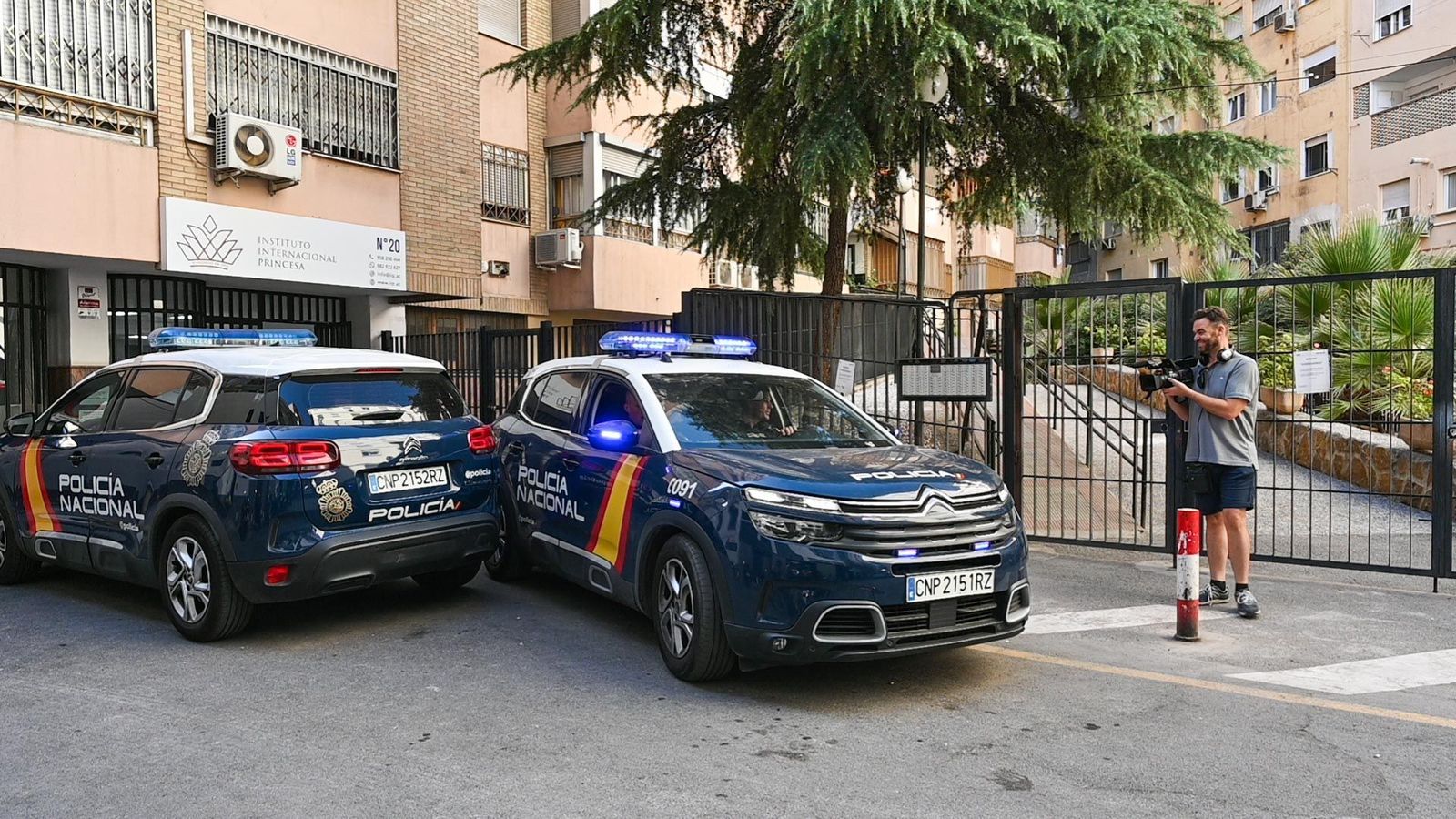 Dos coches policiales custodian la entrada al edificio donde sucedieron los hechos