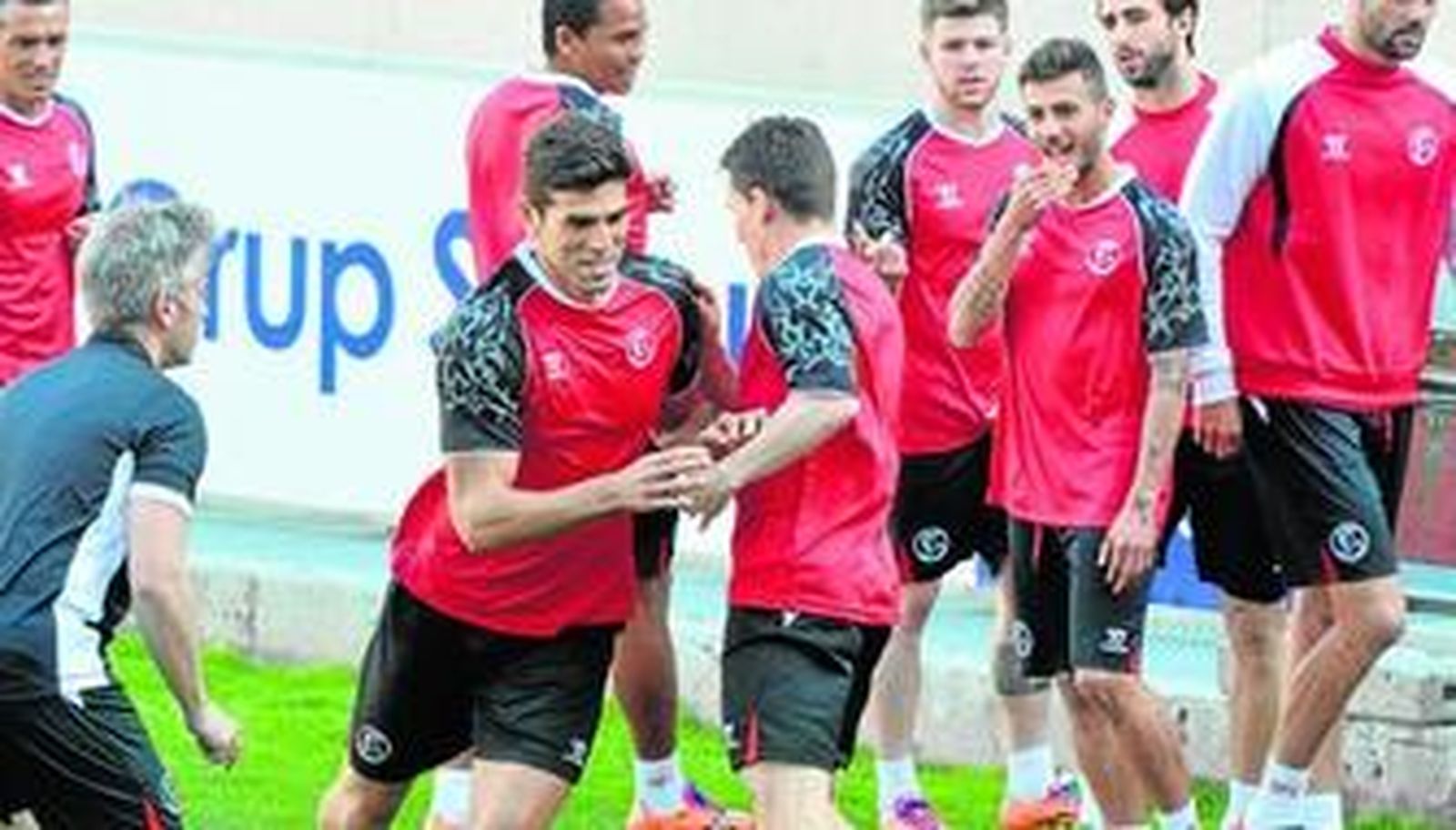 Fazio esquiva a Gameiro ante el preparador físico, Sergio Domínguez, durante un entrenamiento relajado del Sevilla.