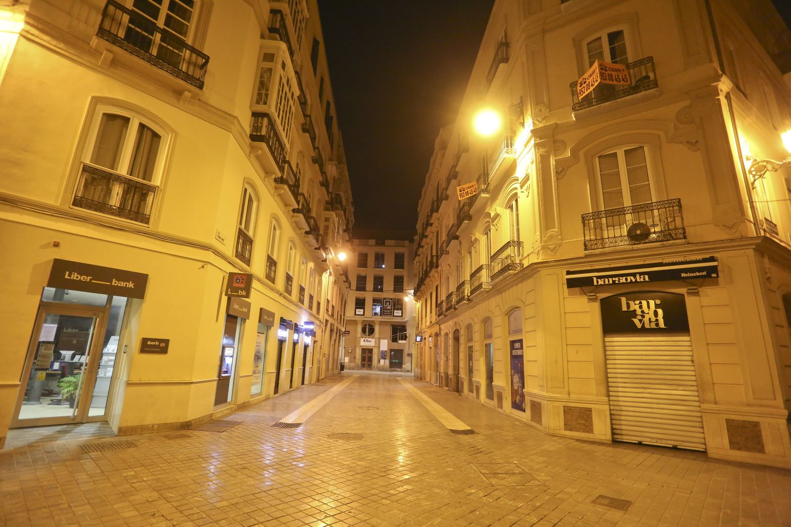 El coronavirus dibuja una noche desierta en el centro de Málaga, en fotos