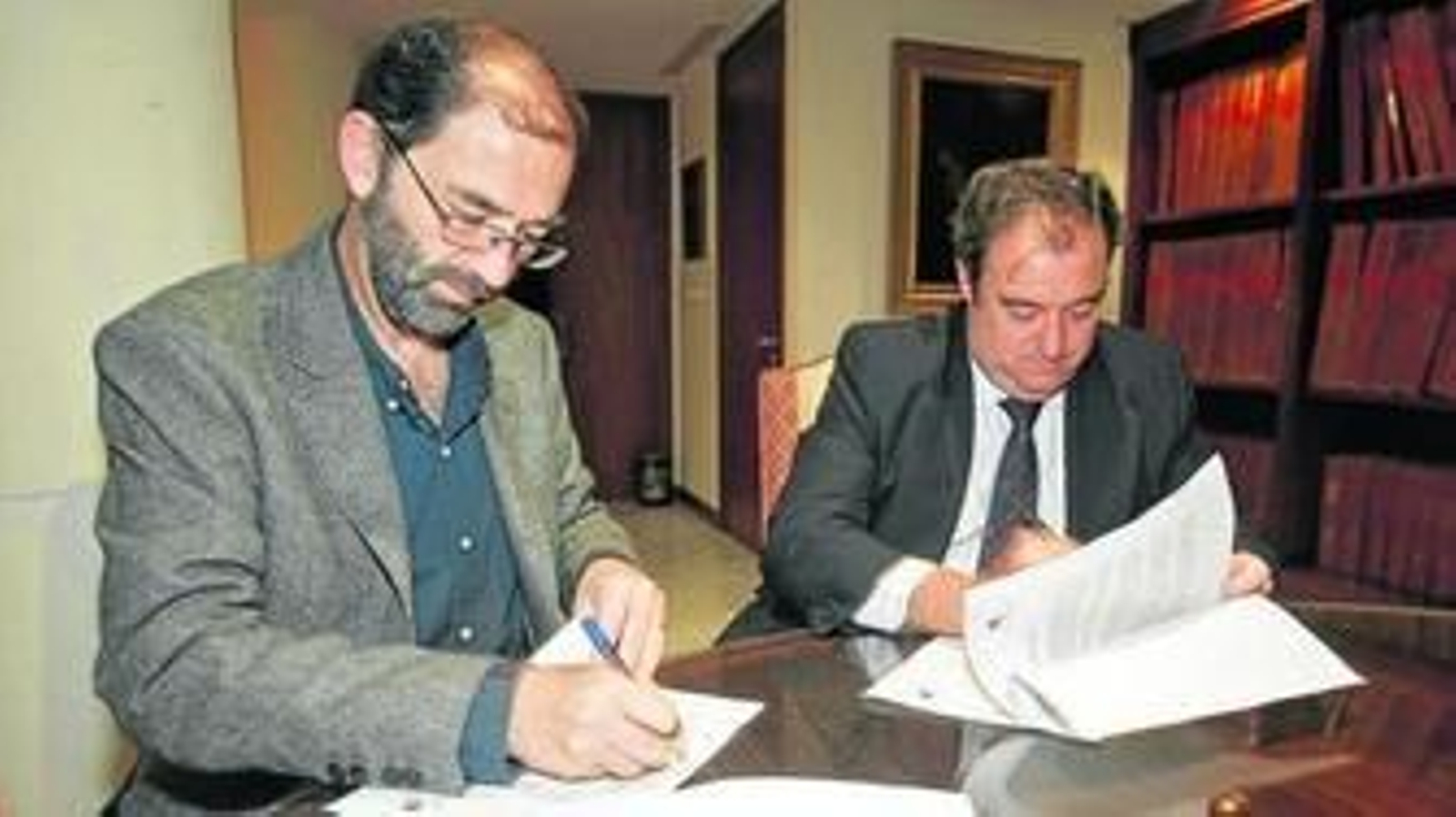 Fernando Santiago, a la izquierda, y Tomás Valiente, firmando el convenio.
