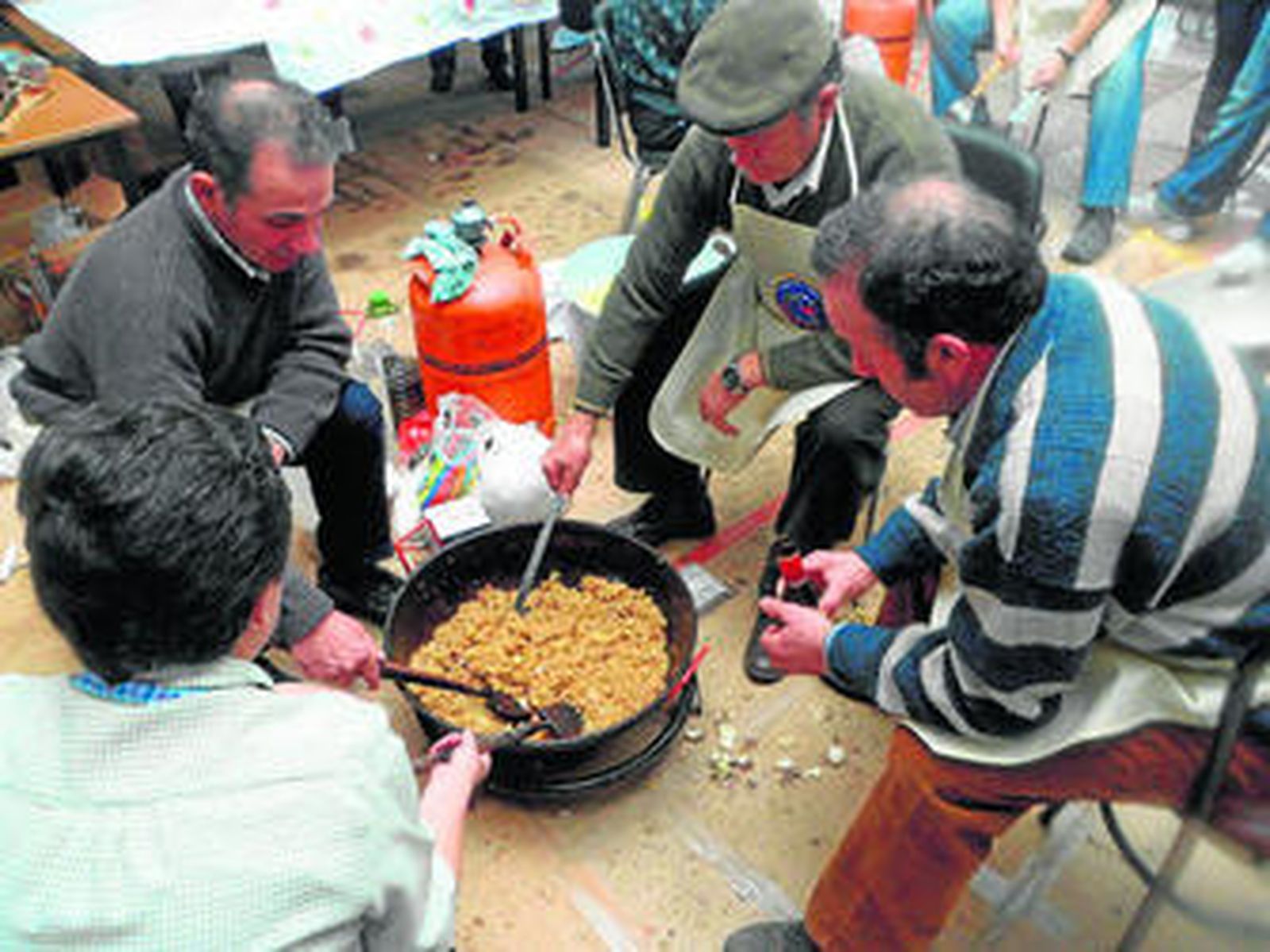 Algunos vecinos de La Umbría elaboran las migas en una edición pasada de esta iniciativa.