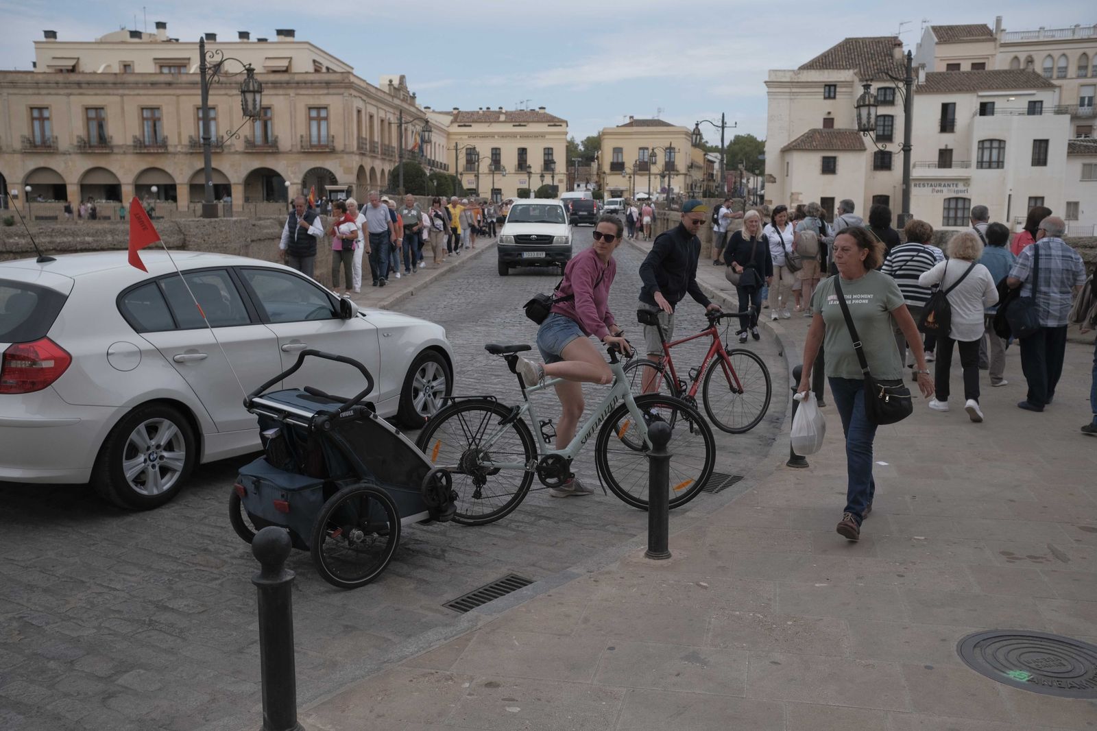 Peatones agolpados en las aceras mientras pasan por el Puente Nuevo.