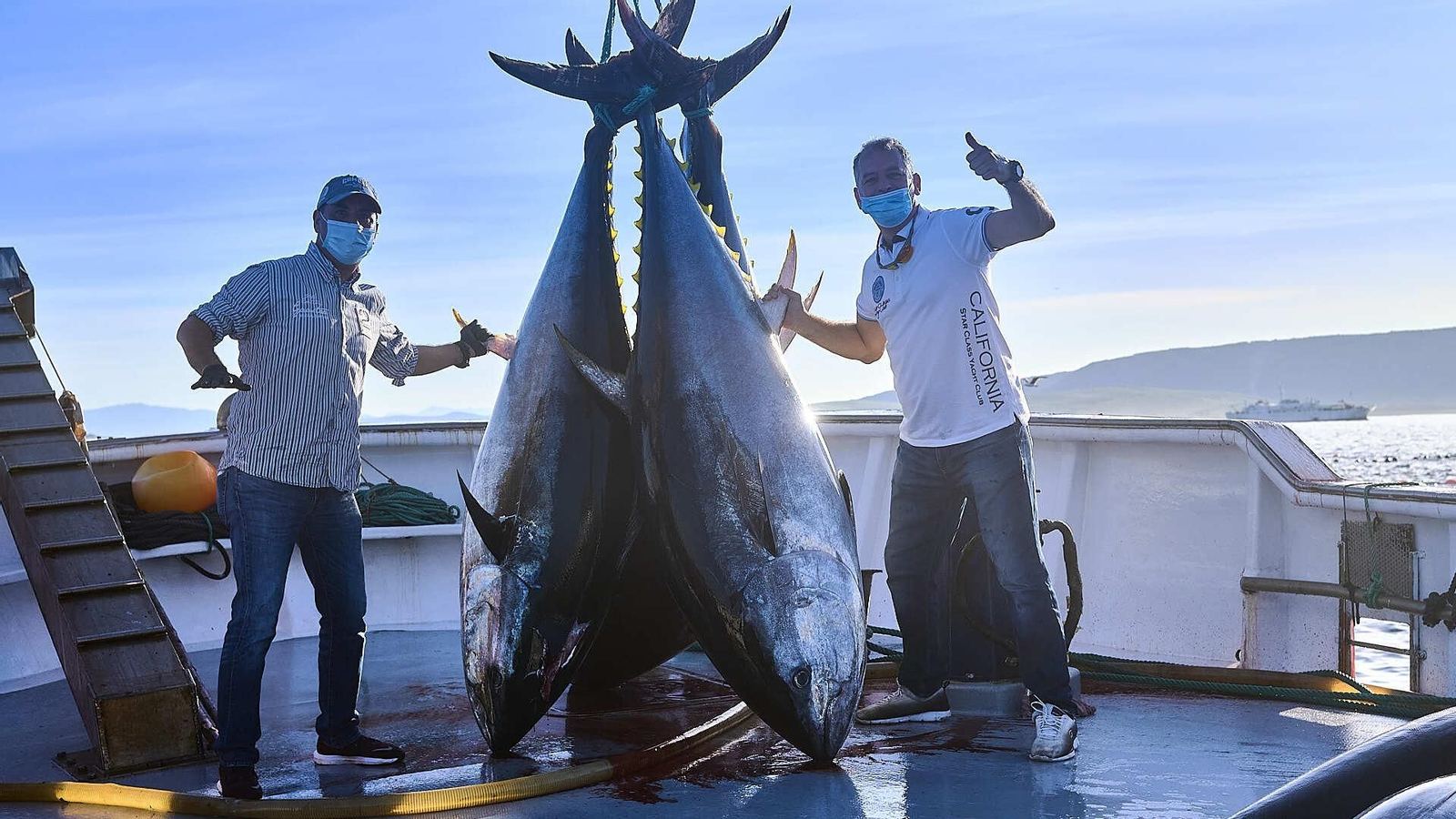 Paco y Pepe Ruiz posando con algunos de los atunes comprados para su restaurante.