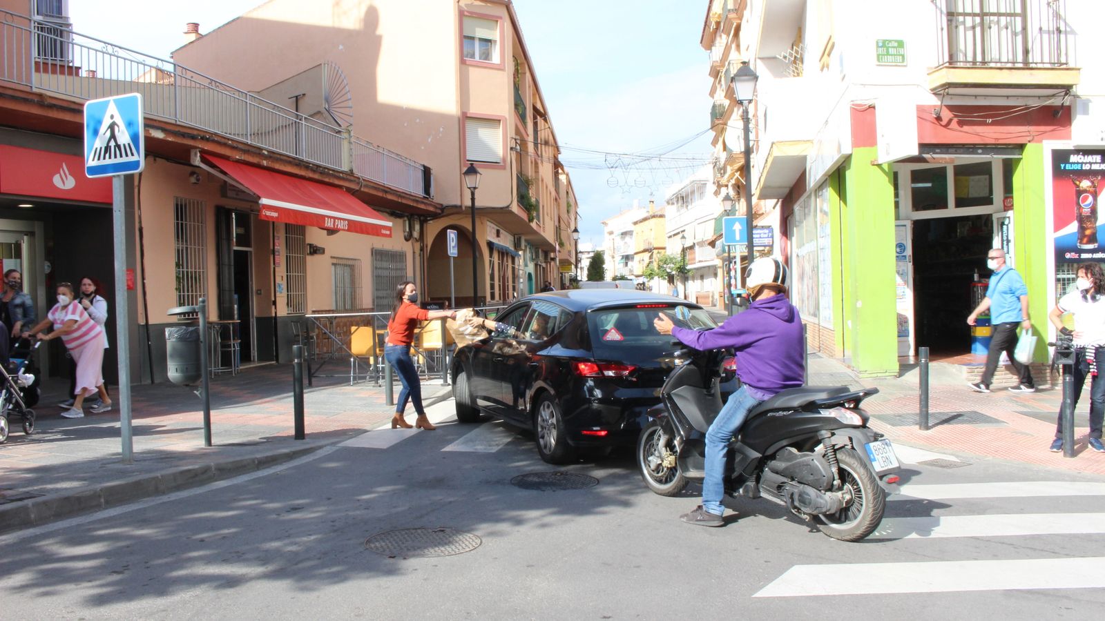 Un comerciante entrega un pedido a un cliente en su vehículo.