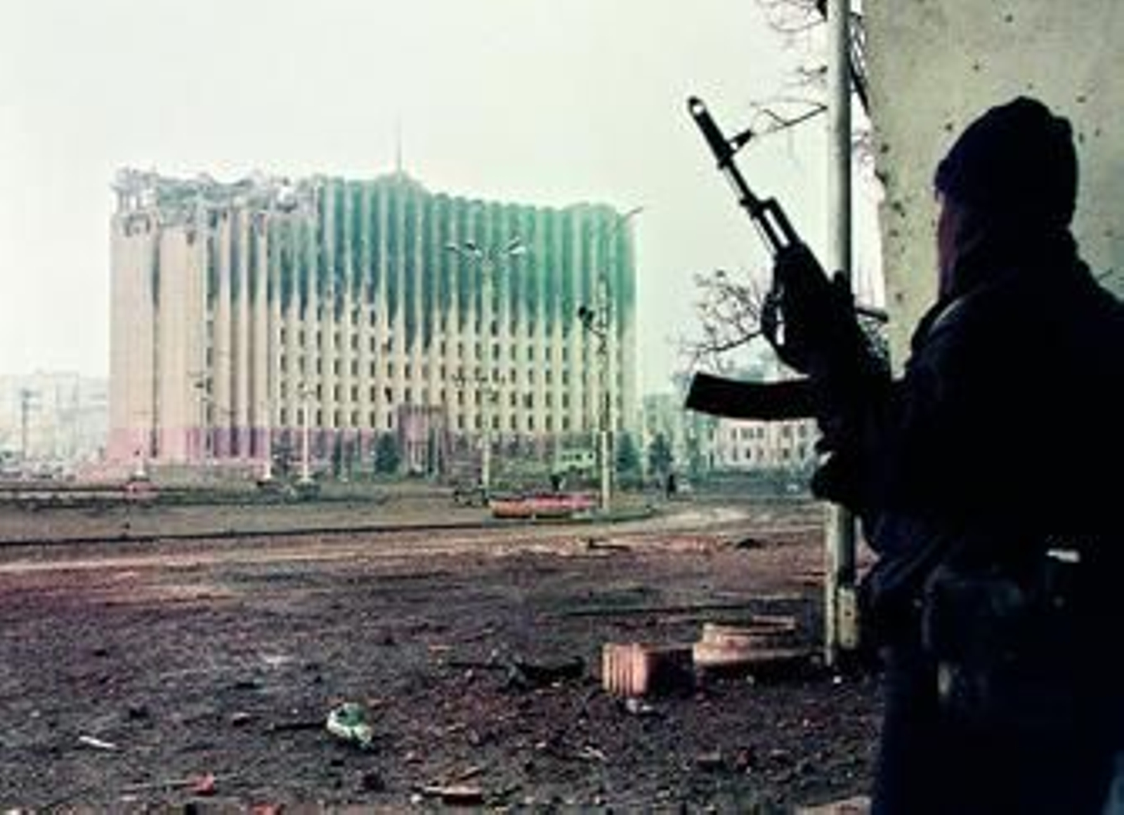 Un guerrillero checheno se cubre en un edificio situado frente al destruido Palacio Presidencial de Grozny, en enero de 1995.