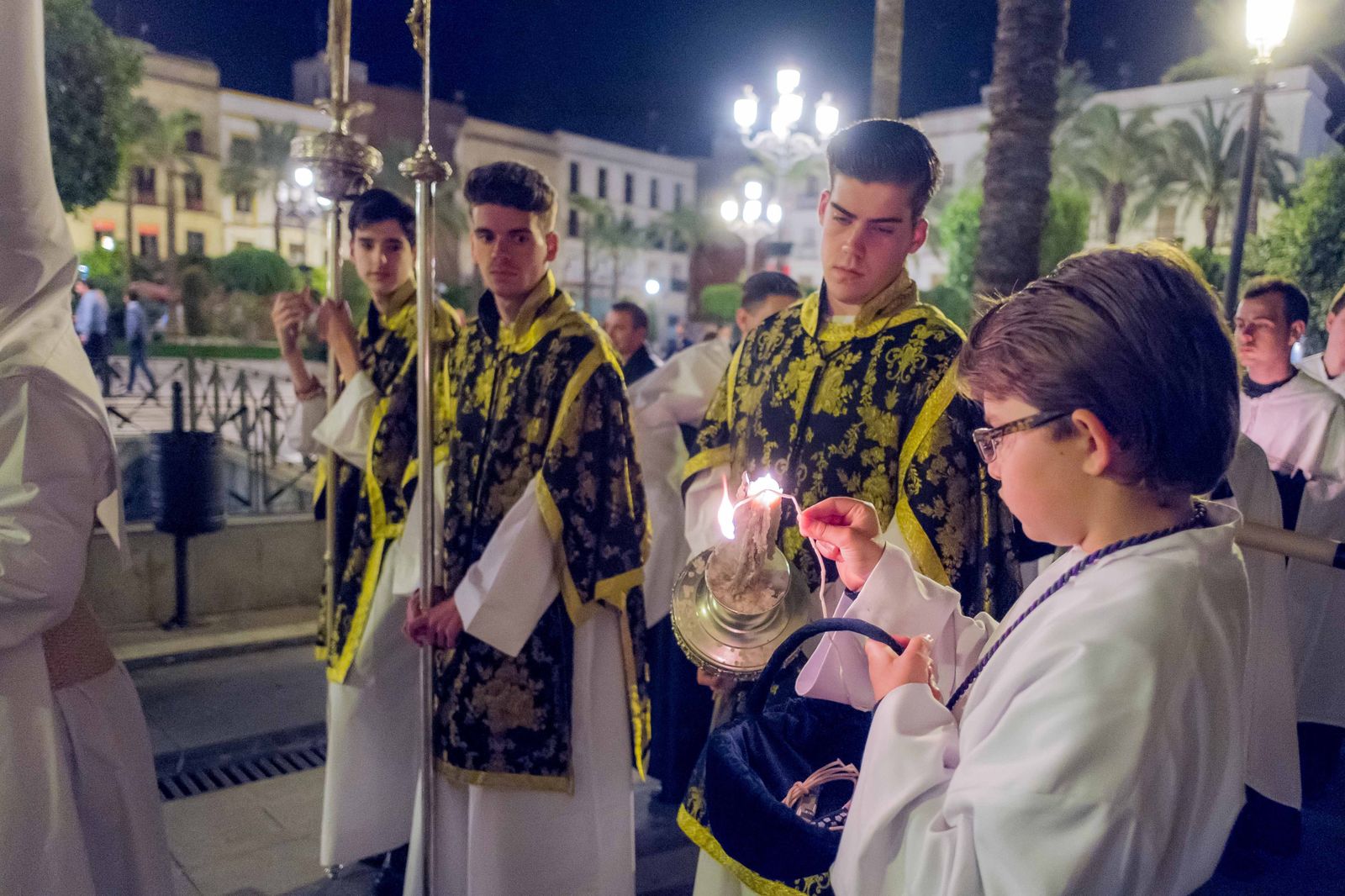 Un niño encendiendo un cirial en las Cinco Llagas.