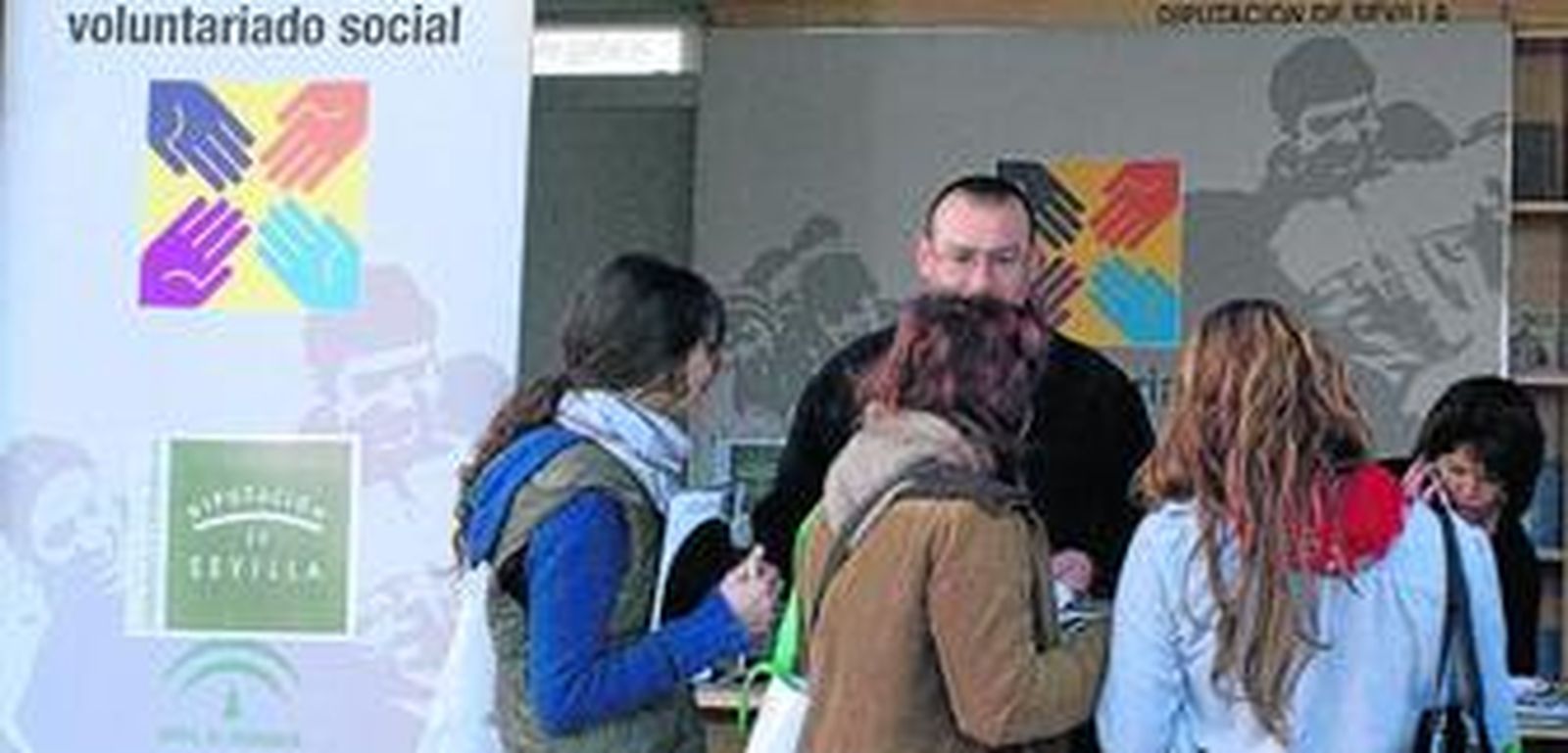 Jóvenes se informan en un 'stand' de voluntariado.