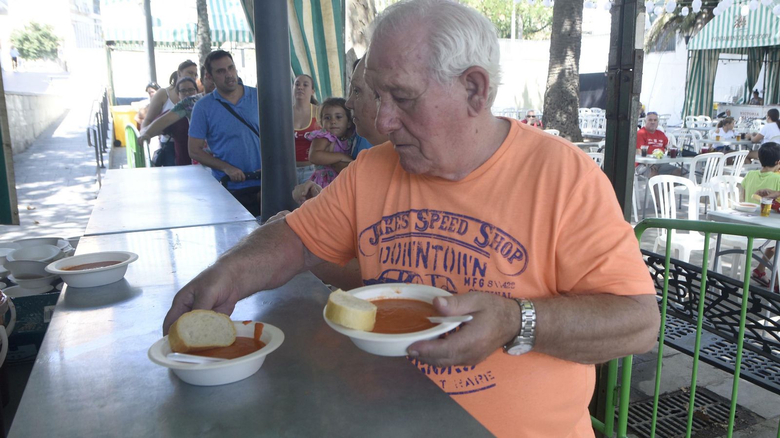 Un hombre recoge su plato de salmorejo.
