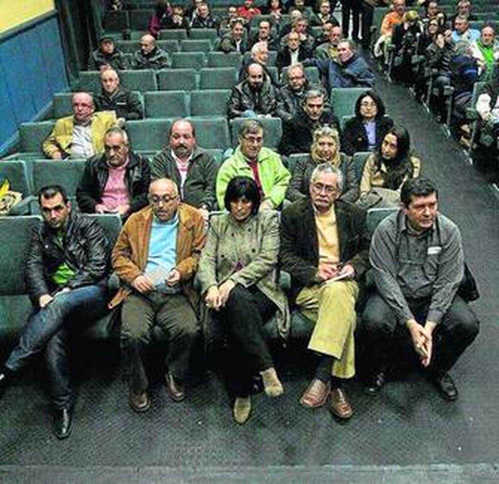 Acosta (i), sentado en la primera fila durante la asamblea, anoche.