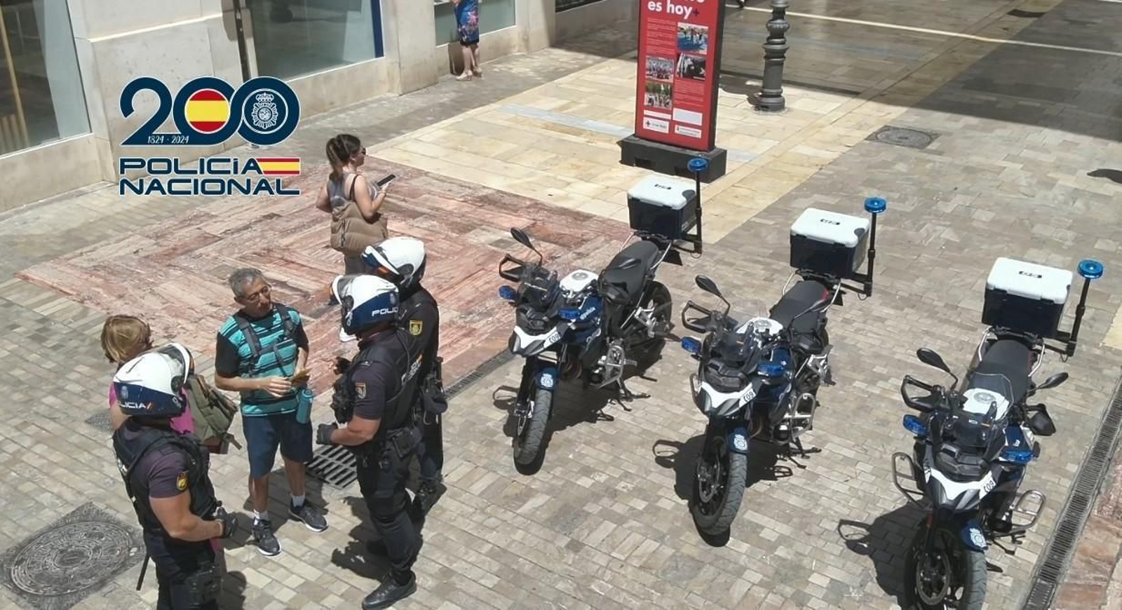 Policías hablando con turistas en una imagen de archivo.