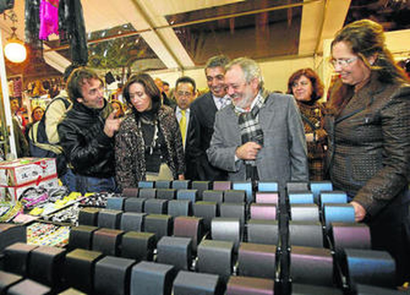 El alcalde, en el centro, atiende las indicaciones de un vendedor de la carpa.