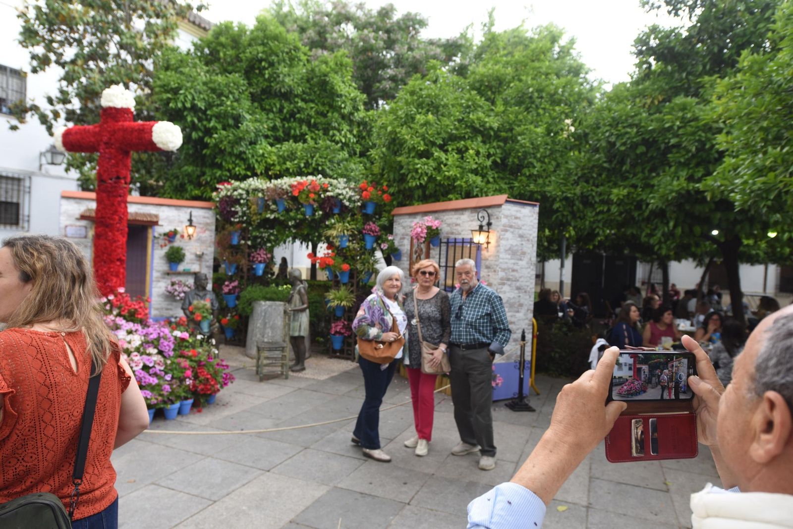 Unos turistas se fotografían ante una Cruz de Mayo.